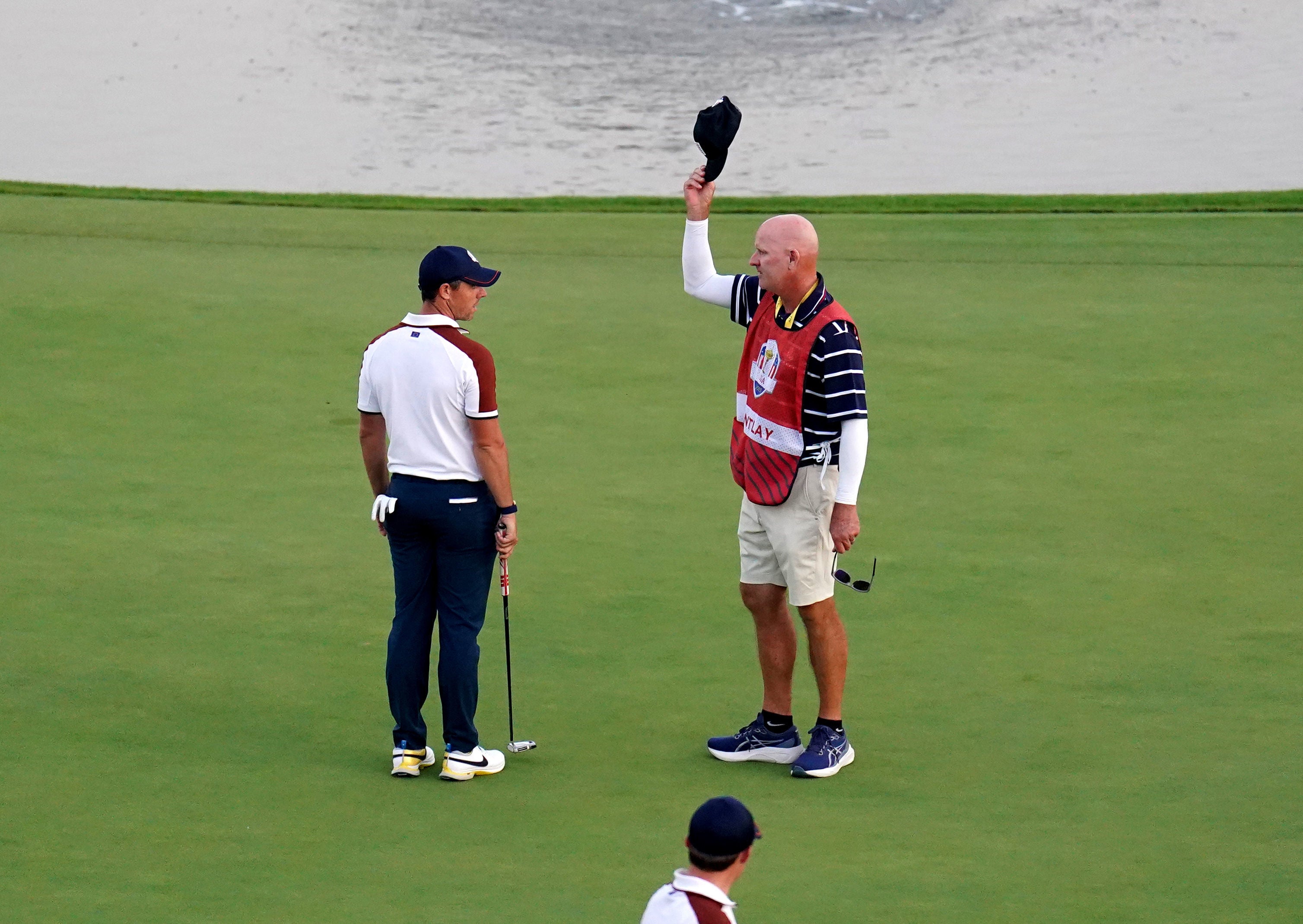 McIlroy stares down LaCava on the 18th green