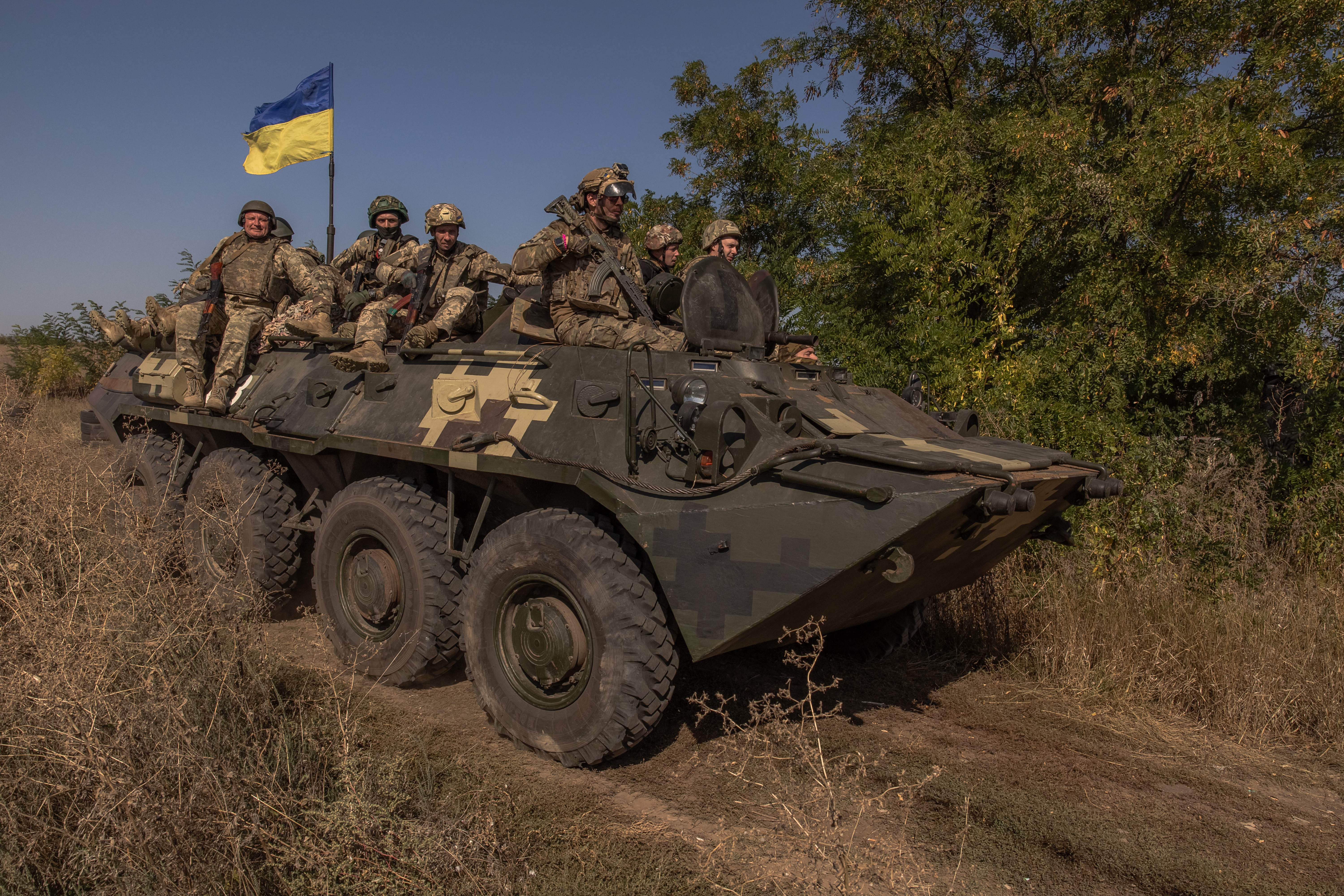 Ukrainian members ride on top of an armoured personnel carrier as they take part in a military training in the Donetsk region