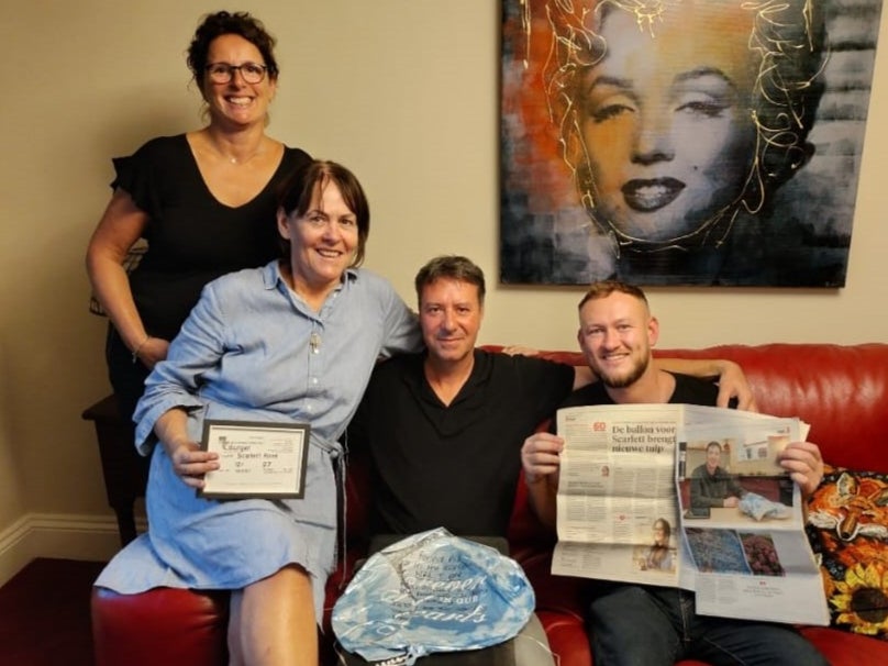 Marisska Burger (left), Kate O’Malley (in blue dress), Pieter Burger and Levi O’Malley (right) with the balloon and a Dutch newspaper article about the story.