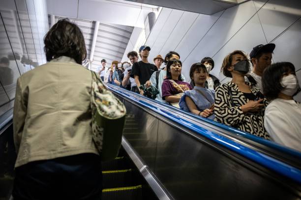 File photo: People ride on an escalator at Shinjuku station in Japan on 1 June 2023