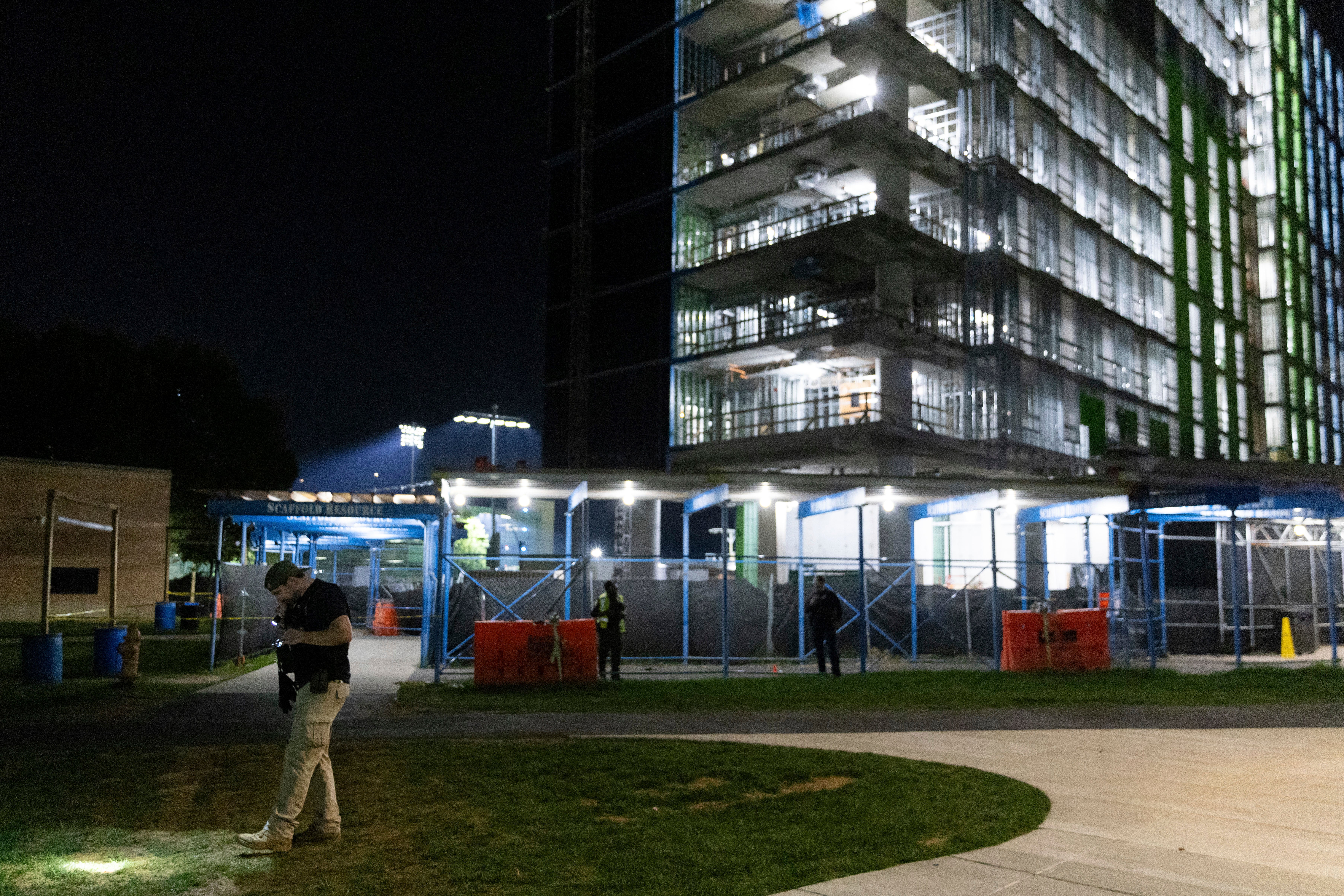 An ATF officer searches for evidence in front of a building at Morgan State University after a shooting, Wednesday, Oct. 4, 2023, in Baltimore