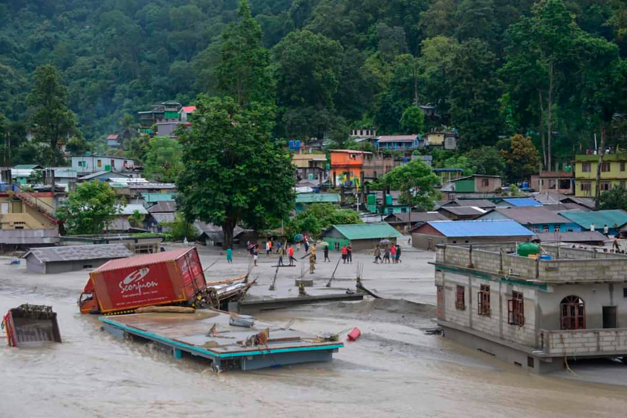 A vehicle that got washed away lies atop a submerged building after flash floods triggered by a sudden heavy rainfall swamped the Rangpo town in Sikkim, India, Thursday, 5 October 2023