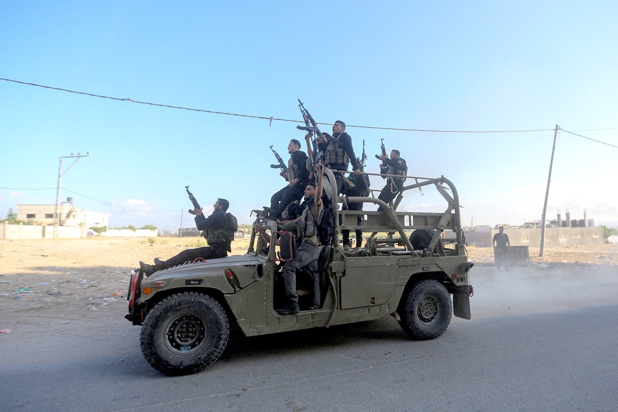 Palestinian militants ride an Israeli military vehicle that was seized by gunmen who infiltrated areas of southern Israel