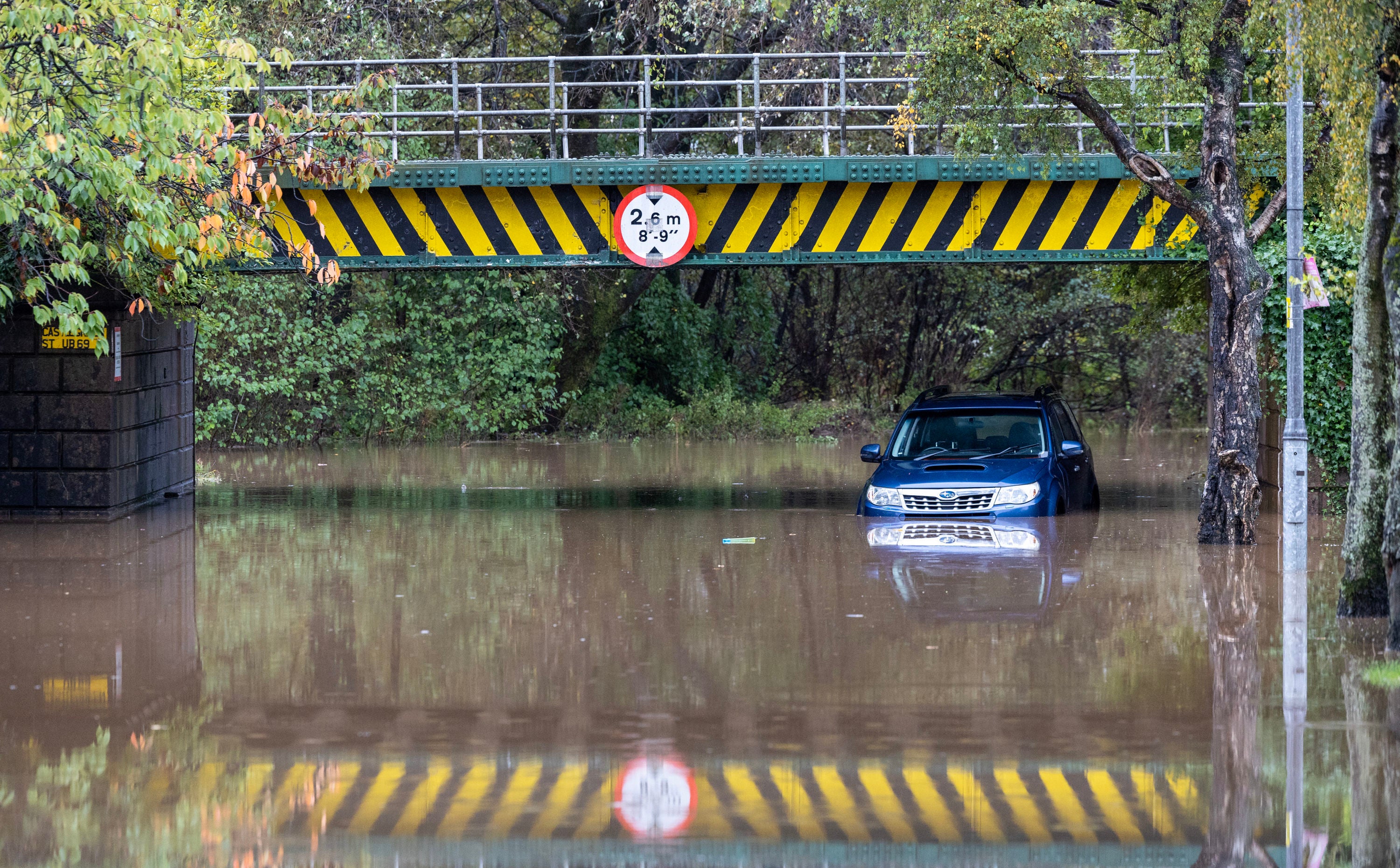 A car left abandoned under a flooded railway bridge in Dumbarton, Scotland