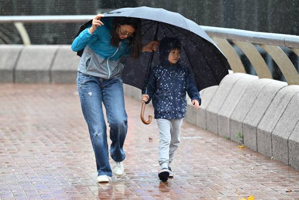 A woman and a child struggle with strong winds as Hong Kong hoisted typhoon signal no 8 around noon on 8 October