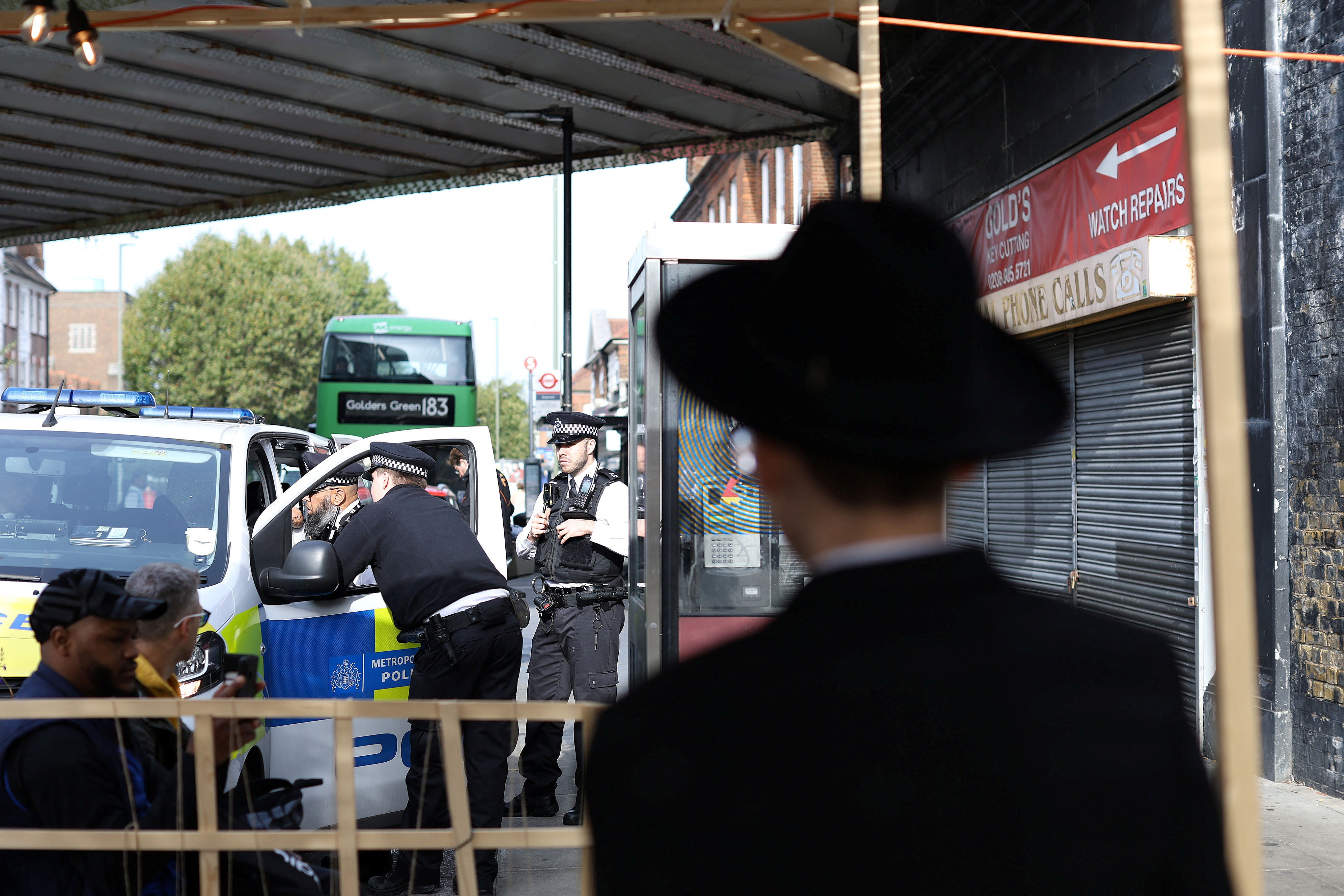 Police officers stand by the vandalised Kosher restaurant in Golders Green