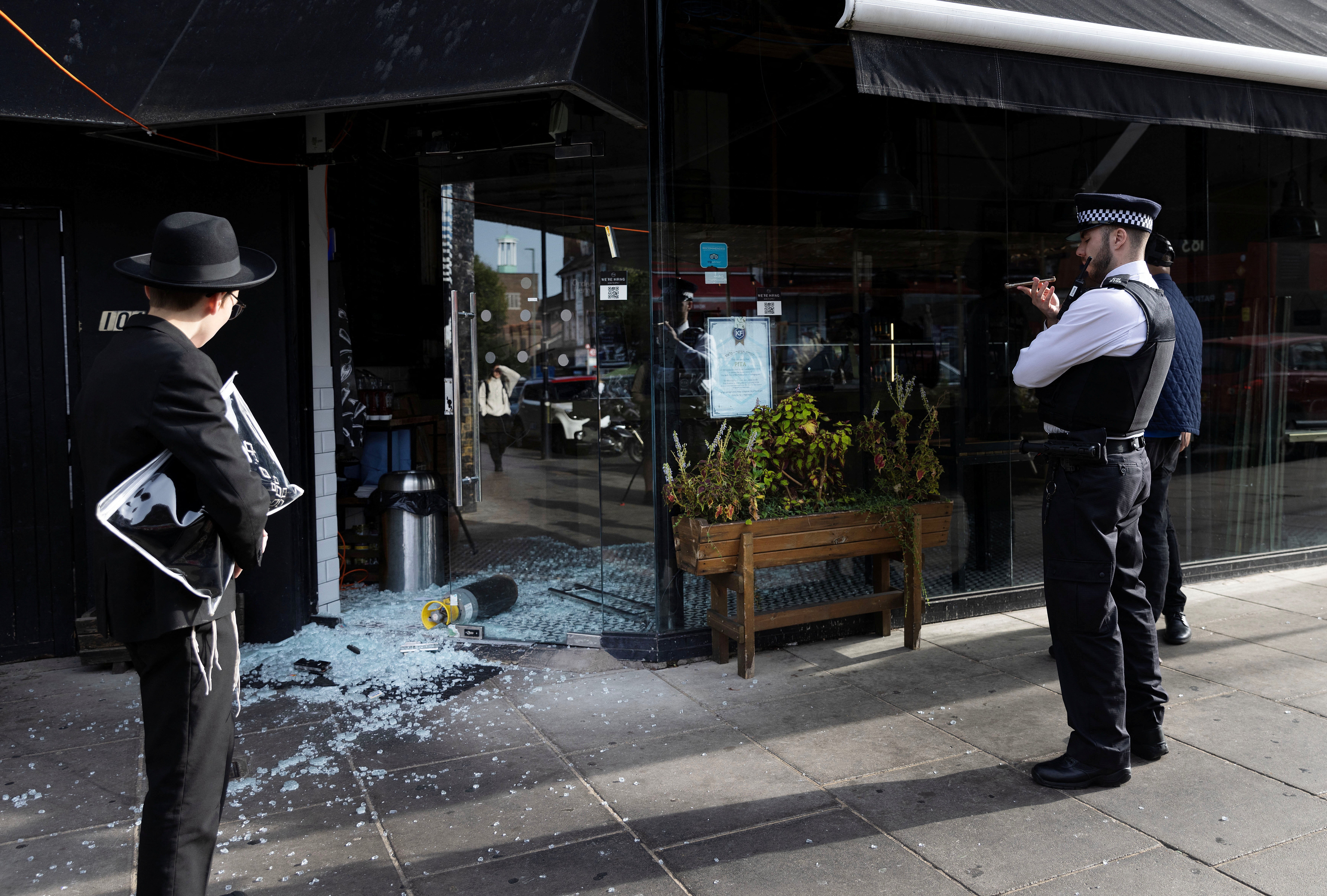 A police officer outside the vandalised restaurant