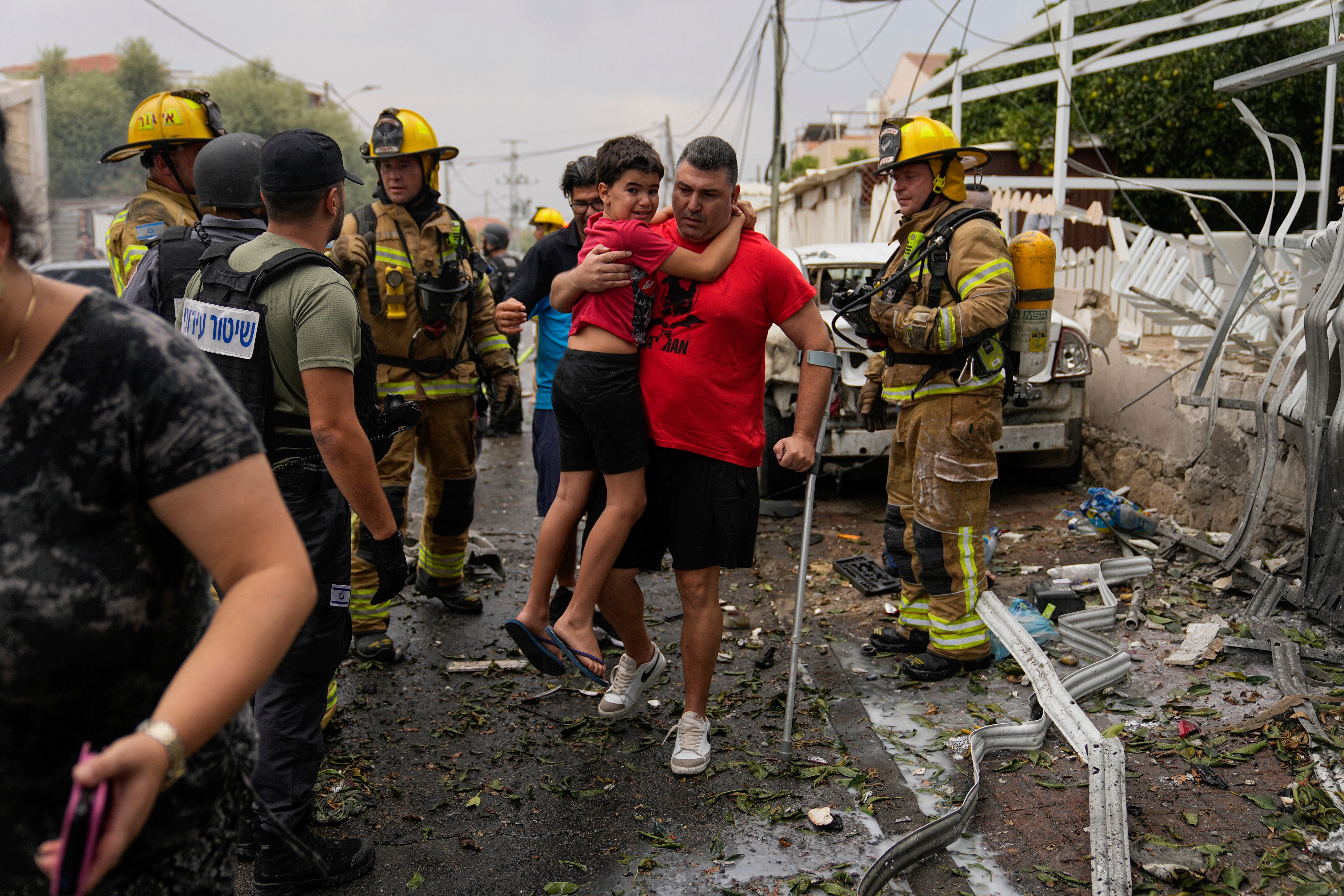 Israelis evacuate a site struck by a rocket fired from the Gaza Strip, in Ashkelon on Monday 9 October