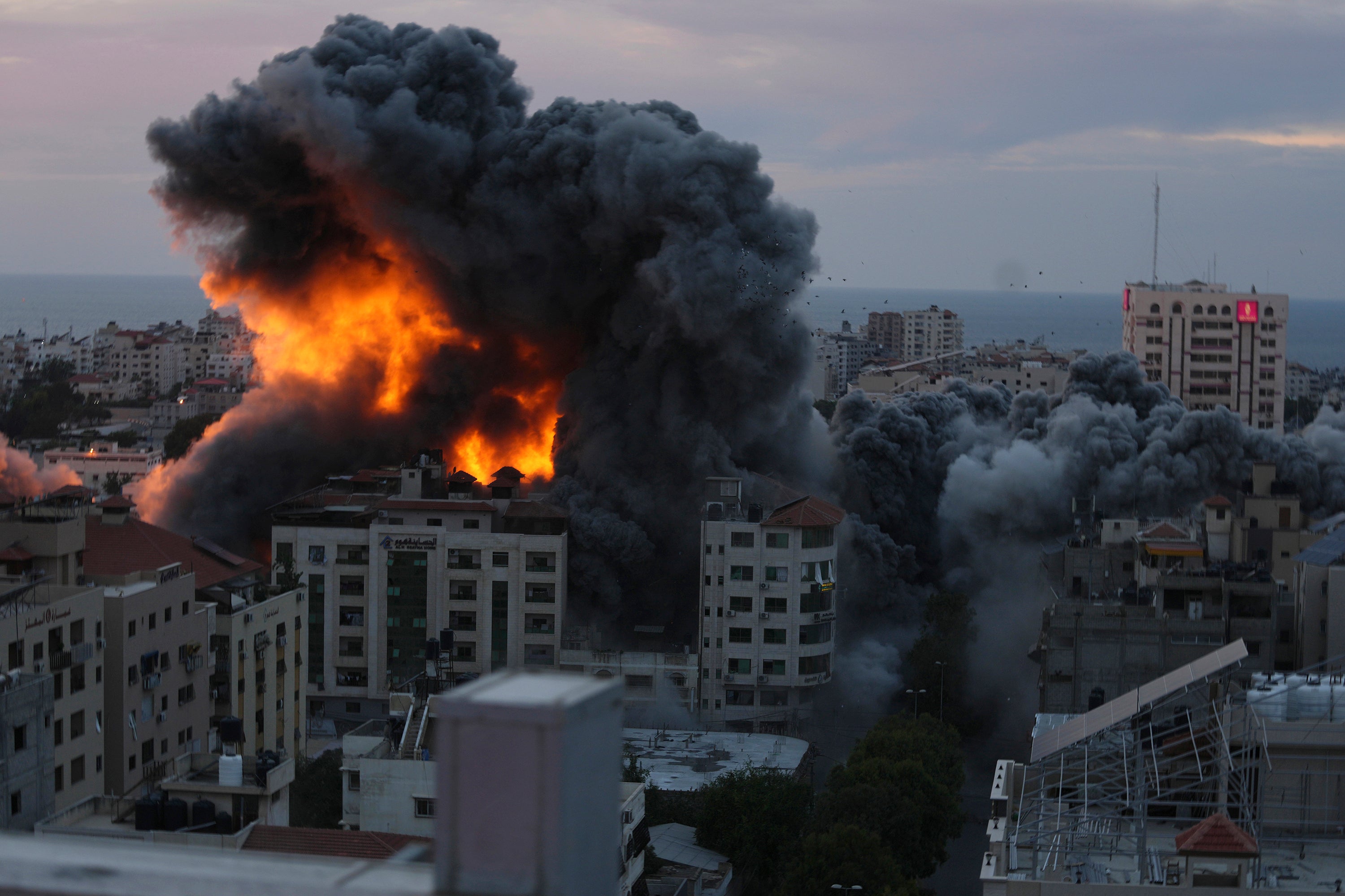 Fire and smoke rise from an explosion on a Palestinian apartment tower following an Israeli air strike in Gaza City