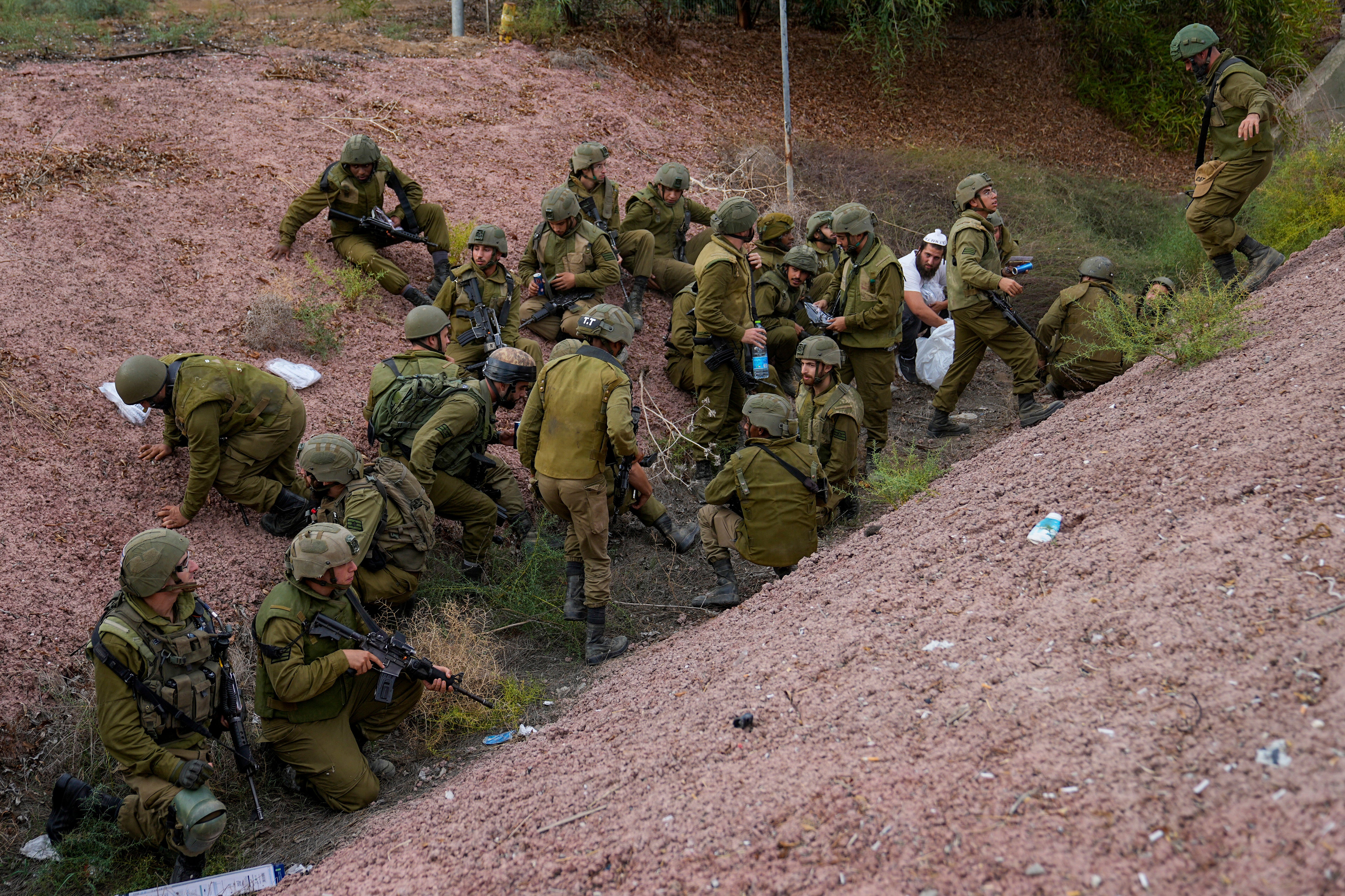 Soldiers and a civilian take cover as a siren sounds a warning of incoming rockets
