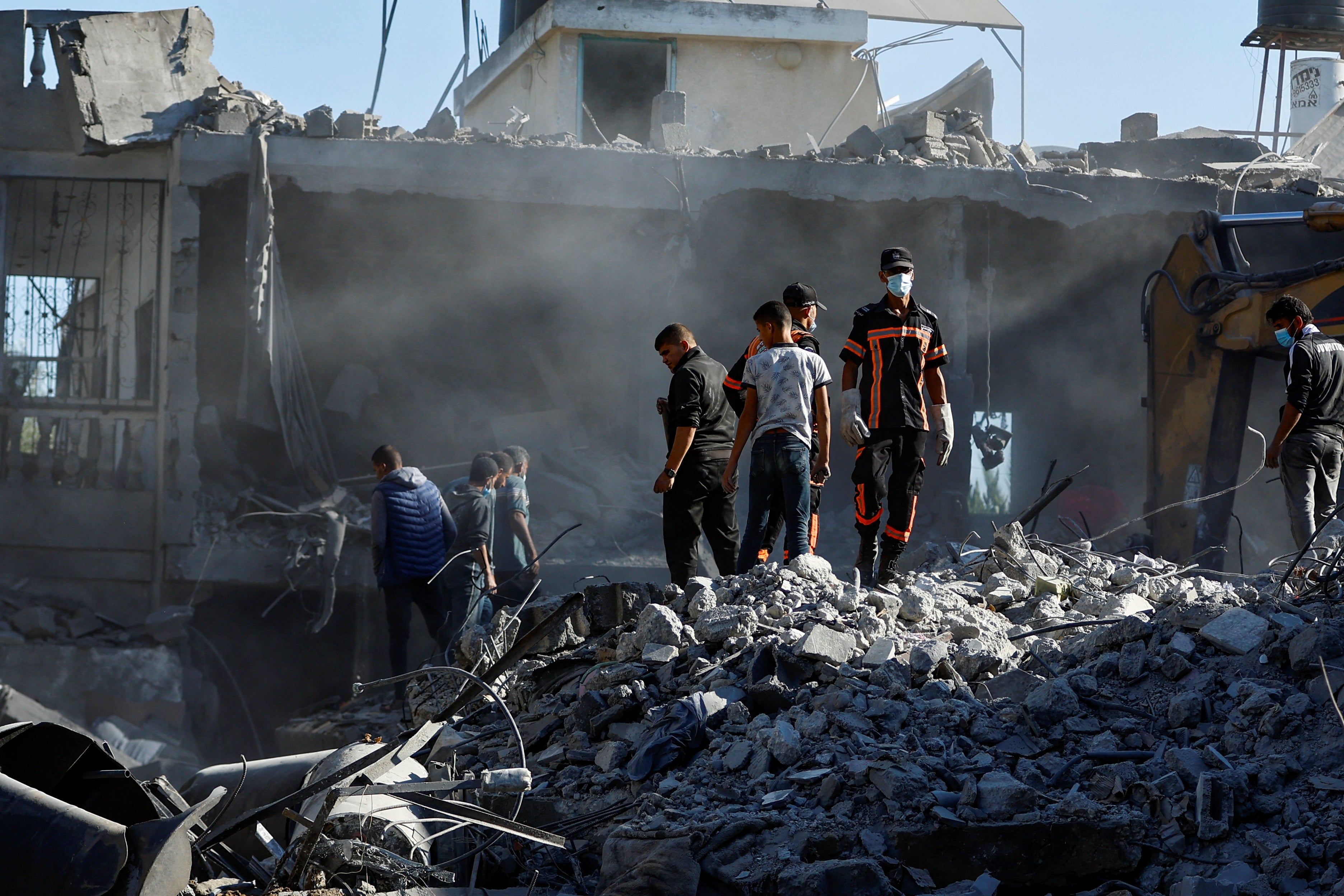 Palestinians search for casualties under the rubble in the aftermath of Israeli strikes