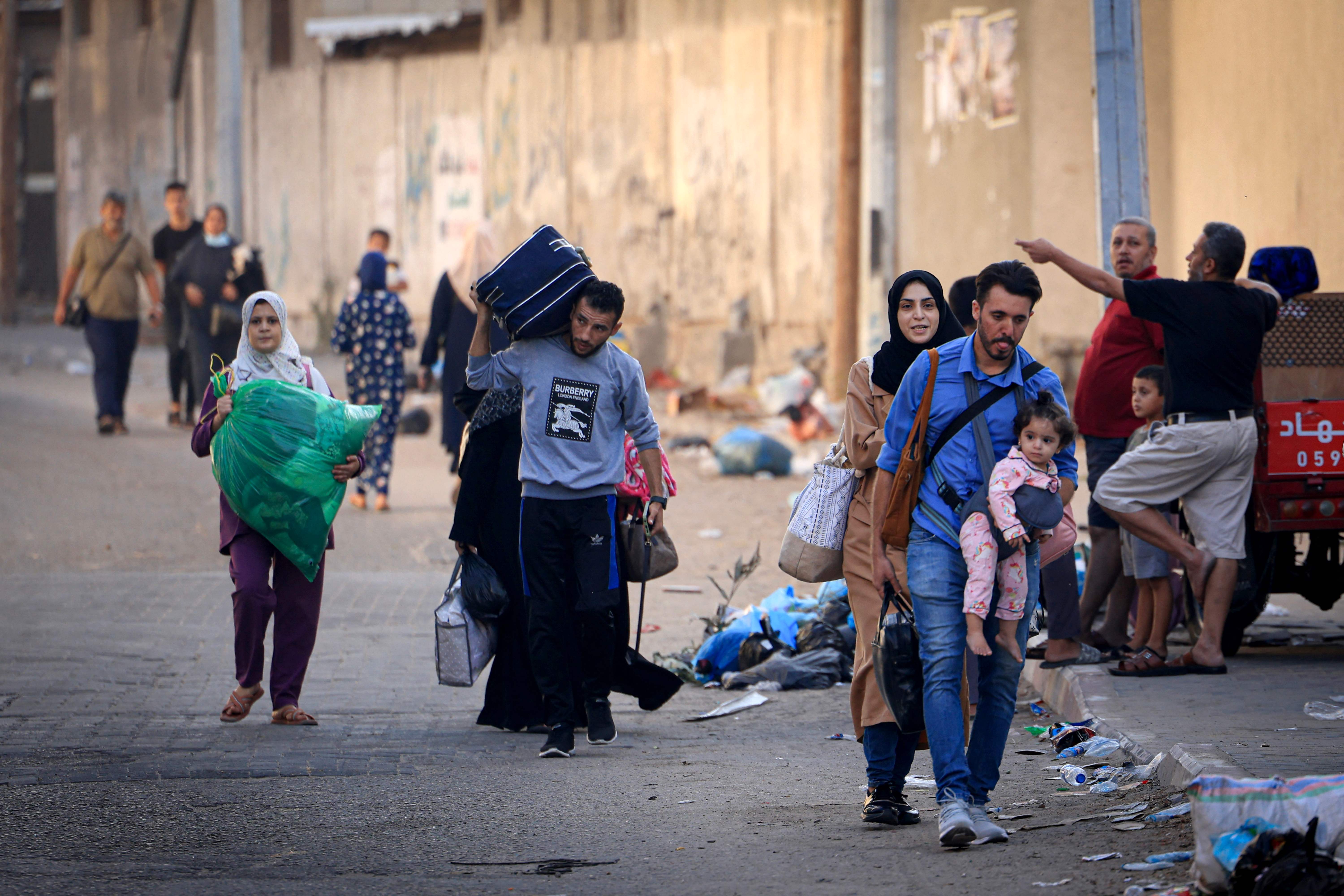 Palestinians with their belongings flee to safer areas in Gaza City after Israeli air strikes