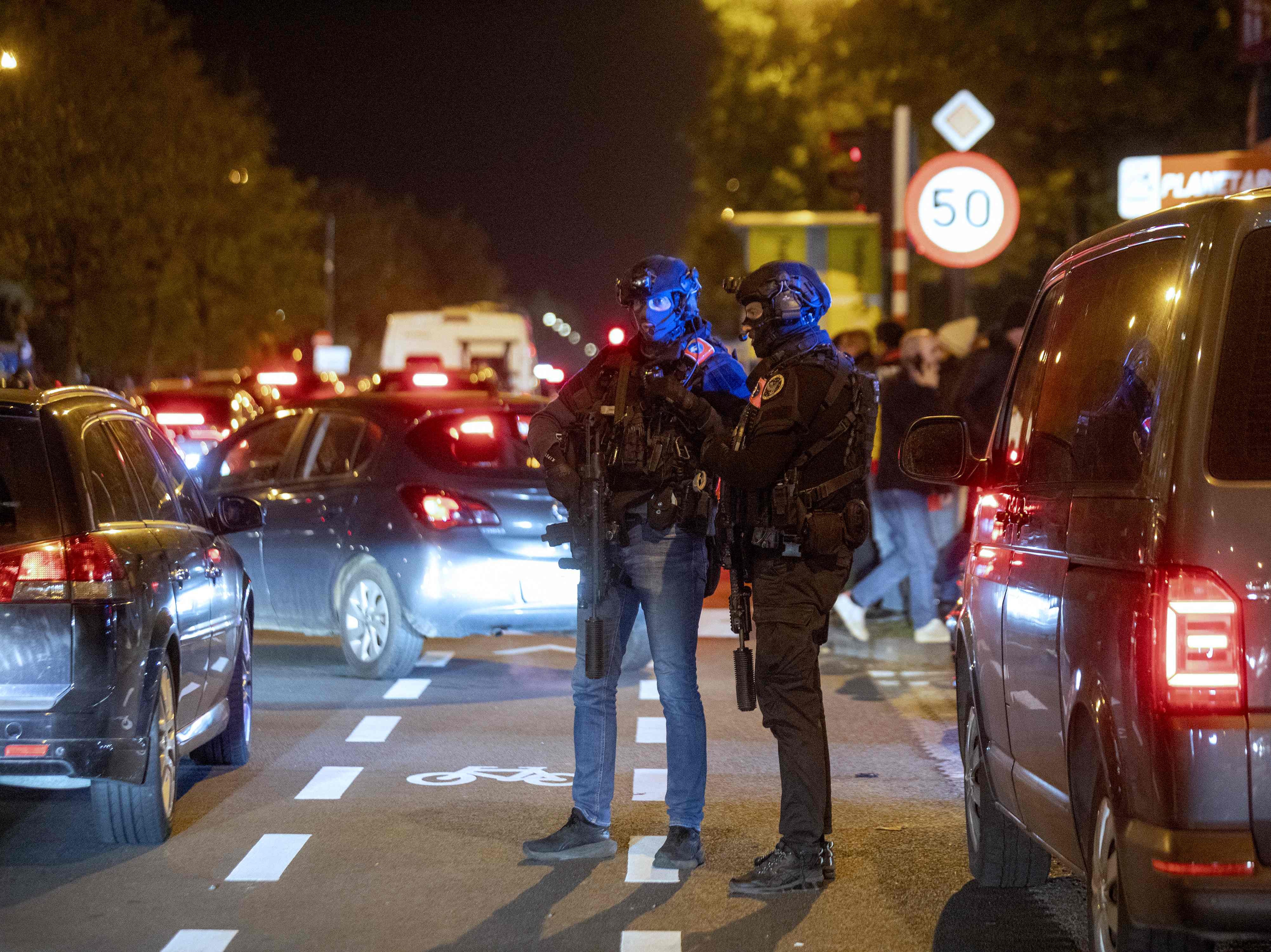 Police officers stand guard as supporters leave the King Baudouin Stadium following the Euro 2024 qualifying football match between Belgium and Sweden in Brussels on October 16, 2023, after two Swedes were shot dead in an attack in Brussels