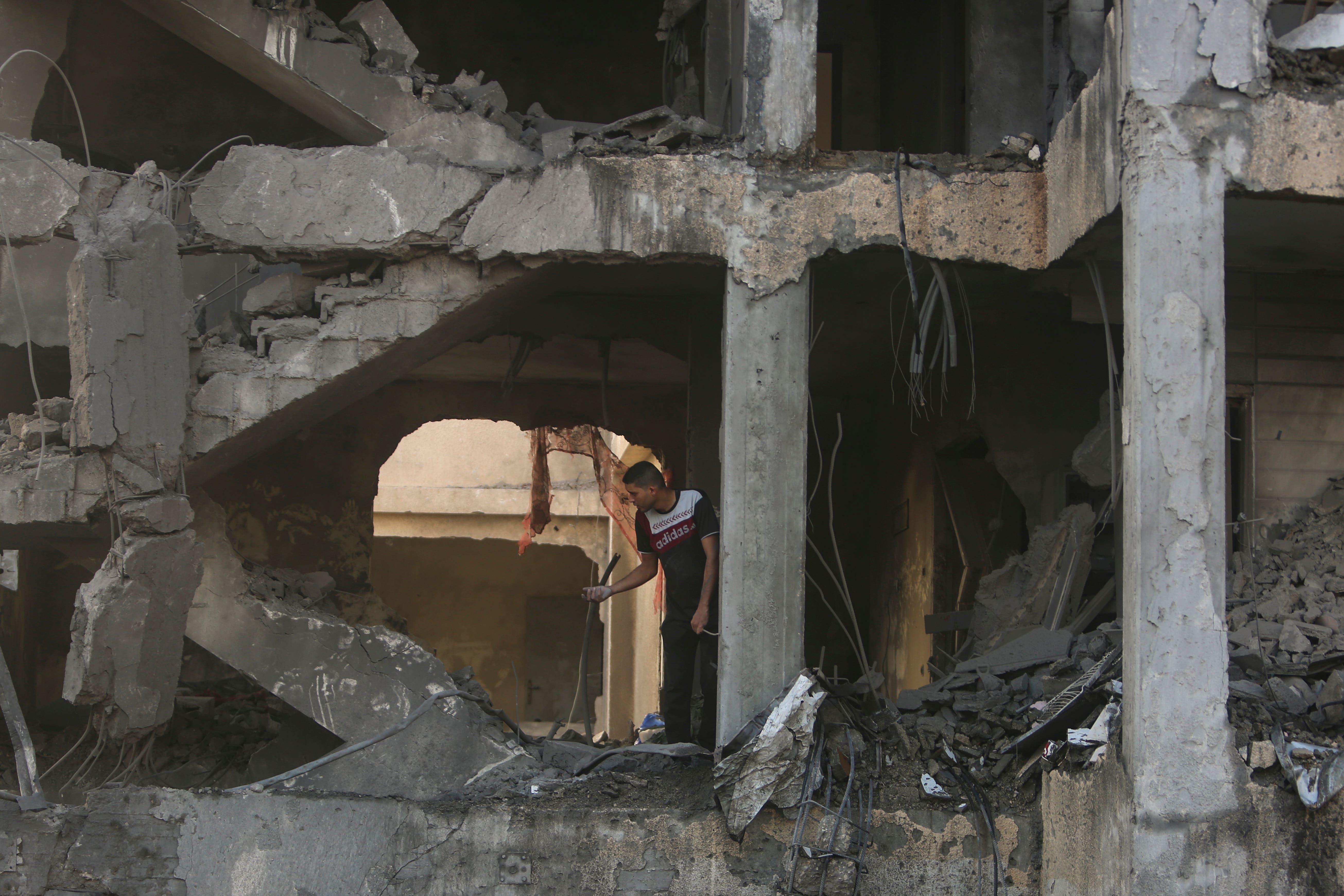 A Palestinian man inspects the remains of a destroyed house hit by an Israeli air strike in the town of Khan Younis (AP Photo/Mohammed Dahman)