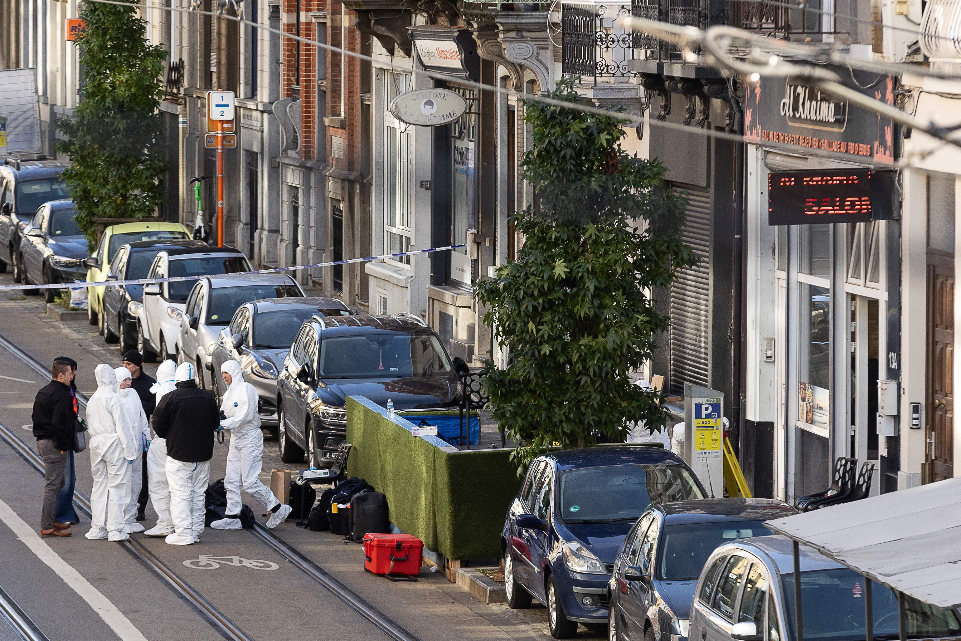 Belgian police officers from the forensic service gather in the street outside the cafe Al Khaima, Brussels