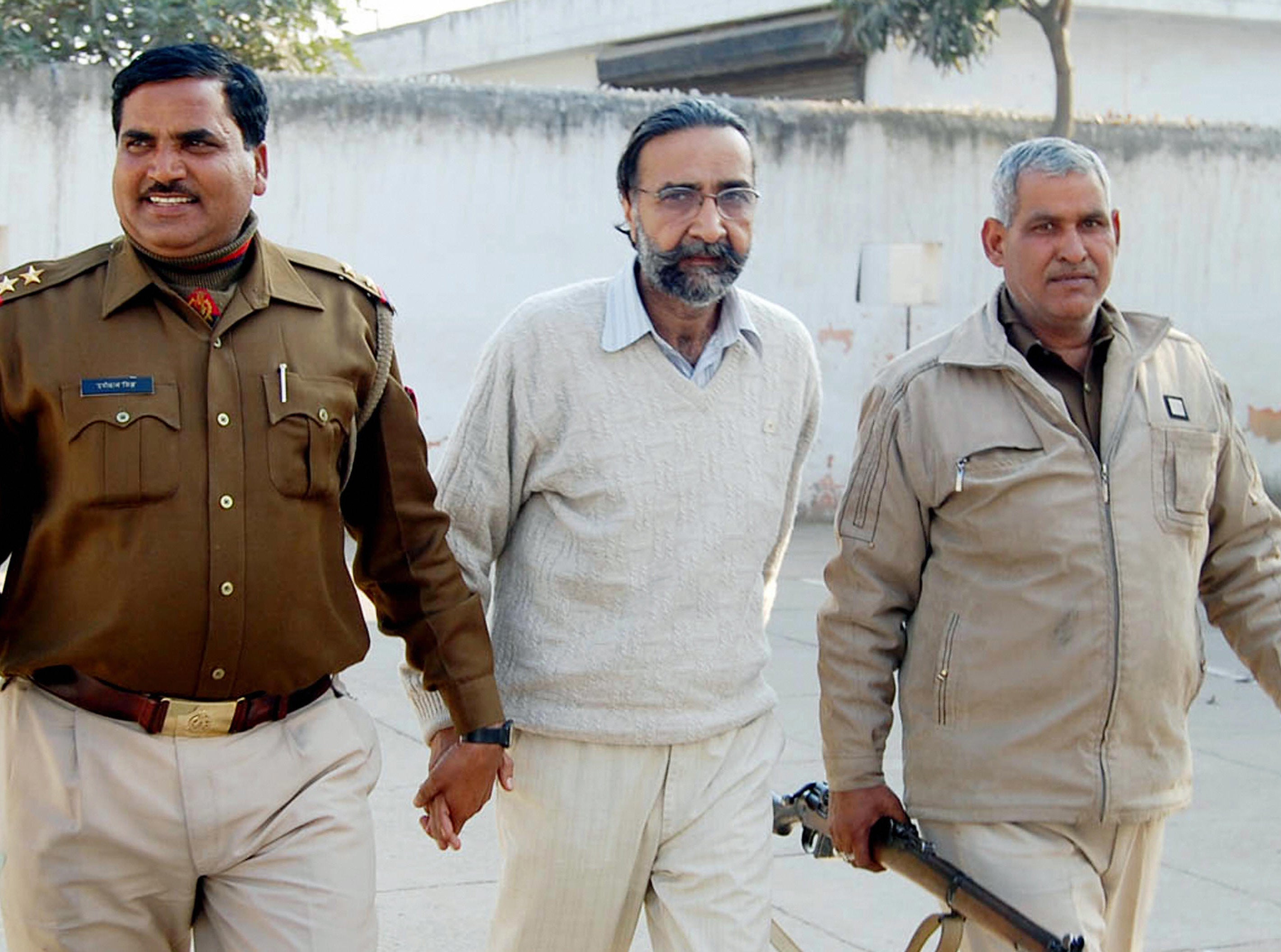 File: Moninder Singh Pandher, (C), joint accused in a case involving the gruesome deaths of 19 people is escorted to court in Ghaziabad