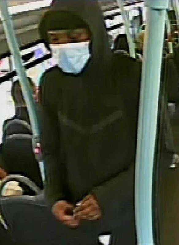 A masked man is seen walking along the bus on CCTV