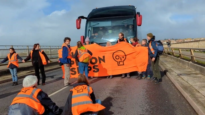 Just Stop Oil protesters block a bus carrying asylum seekers to the Bibby Stockholm barge