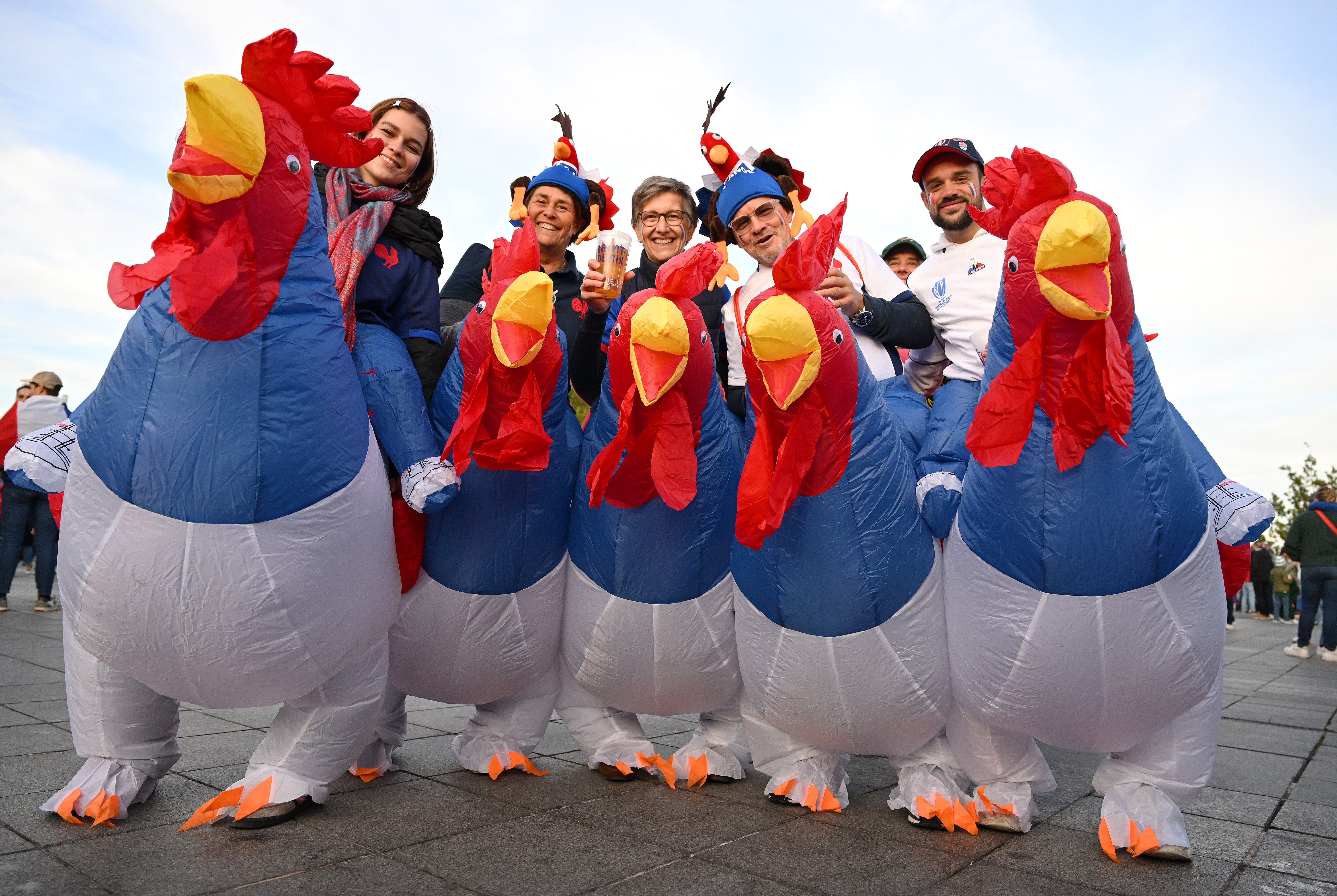 Fans of France wearing fancy dress pose for a photo outside the stadium