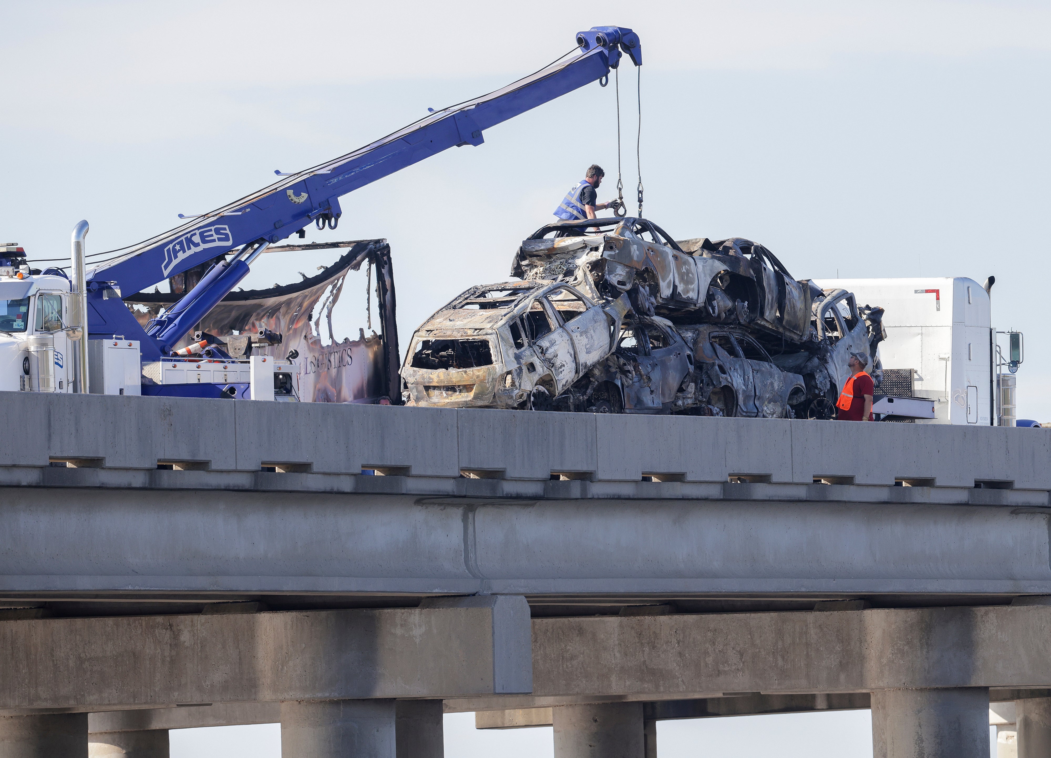 Workers remove heavily damaged vehicles from Interstate 55 near Manchac