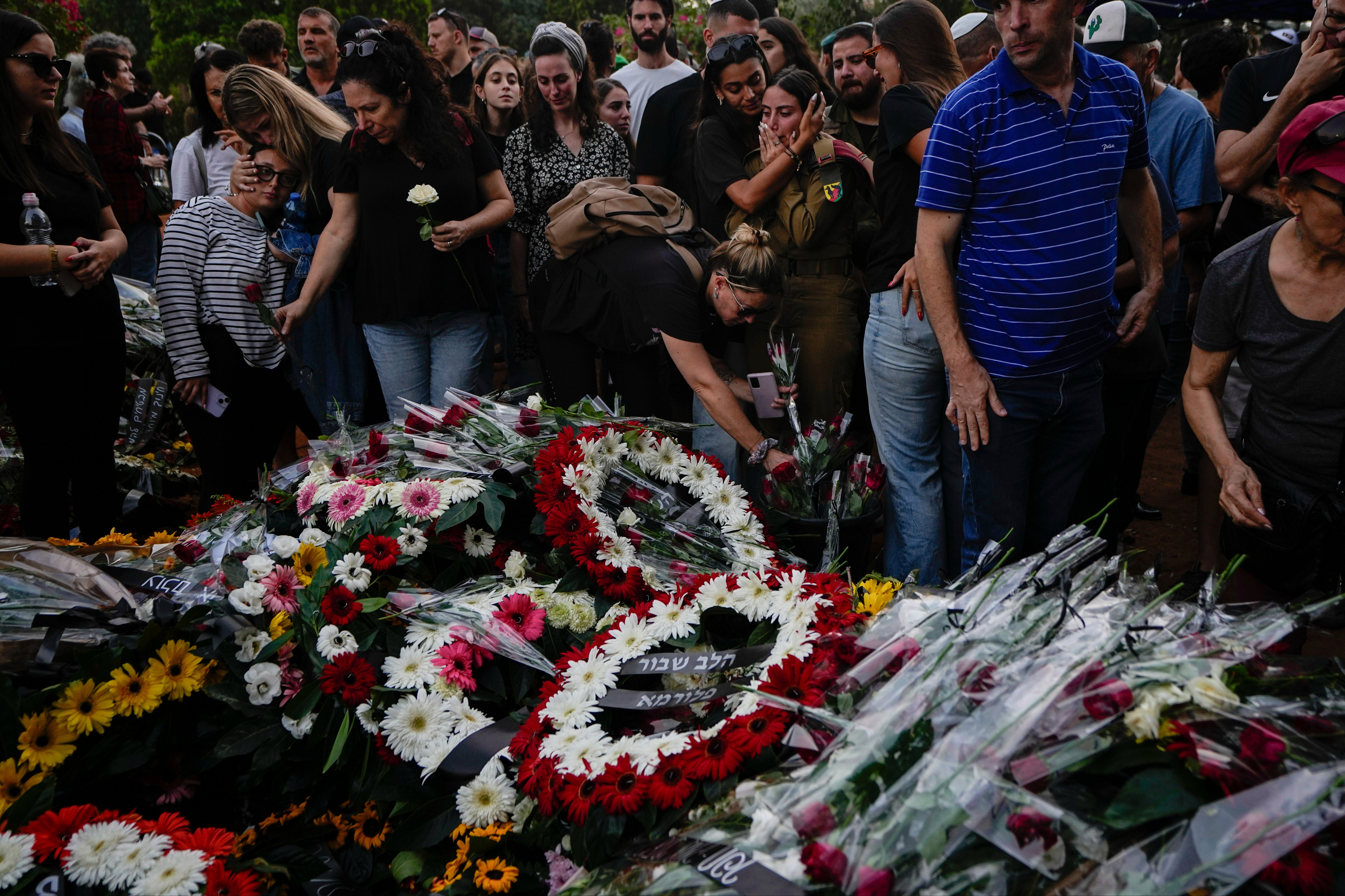 Mourners gather around the graves of Sgt. Yam Goldstein and her father killed by Hamas on 7 October