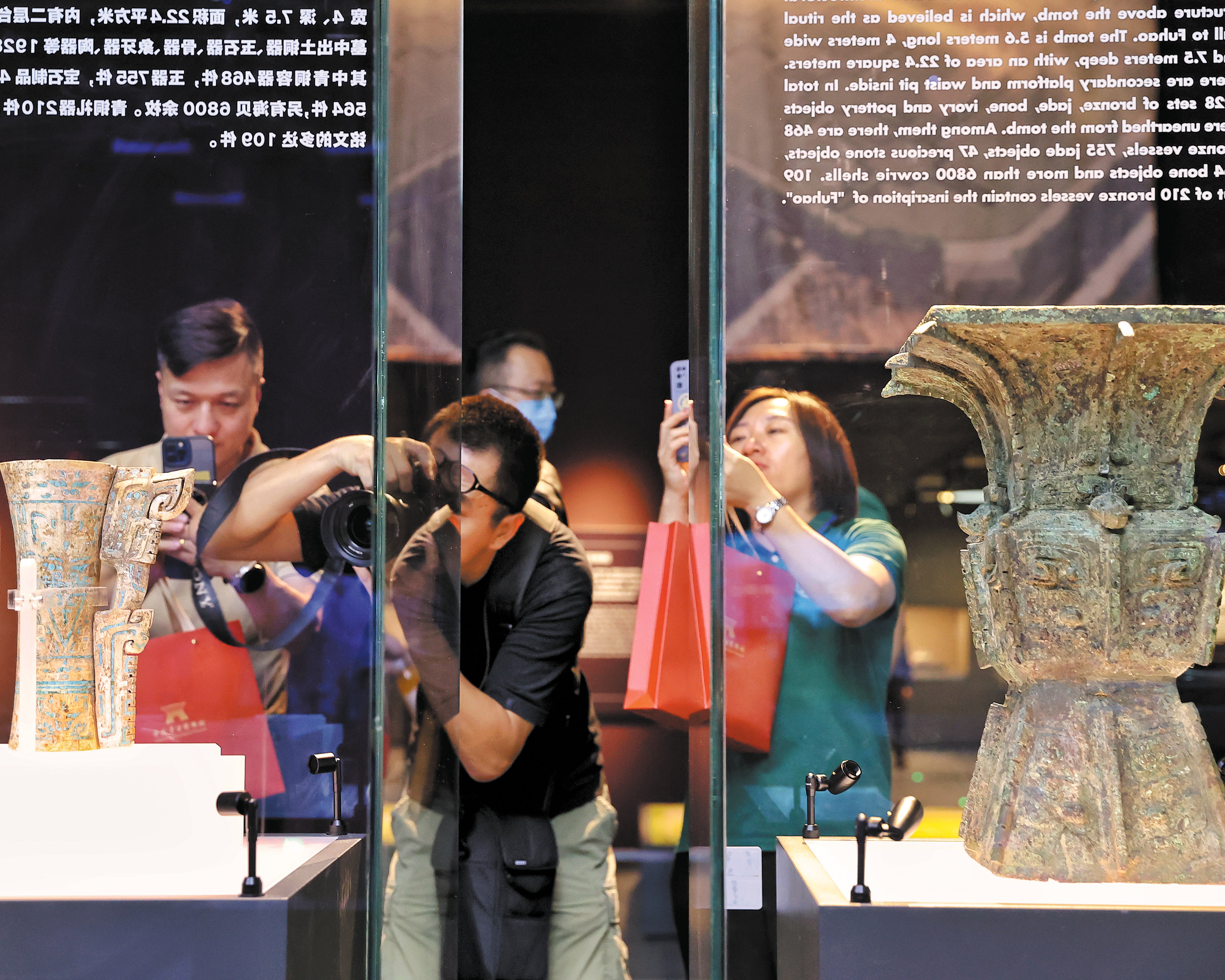 Visitors take photos of cultural relics at the Chinese Archaeological Museum in Beijing, which opened to the public in September, 2023