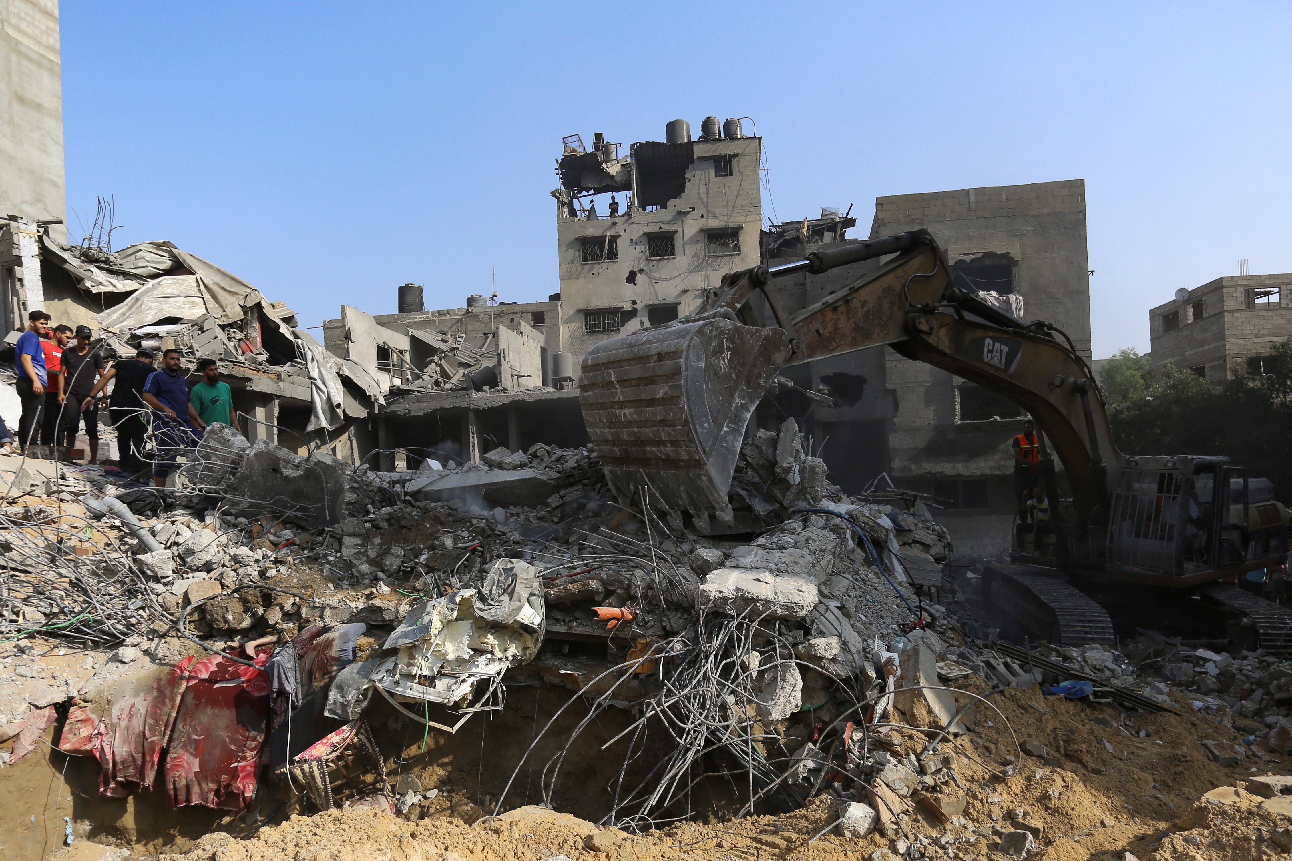 Palestinians inspect the damage of destroyed houses after Israeli airstrikes on Gaza City