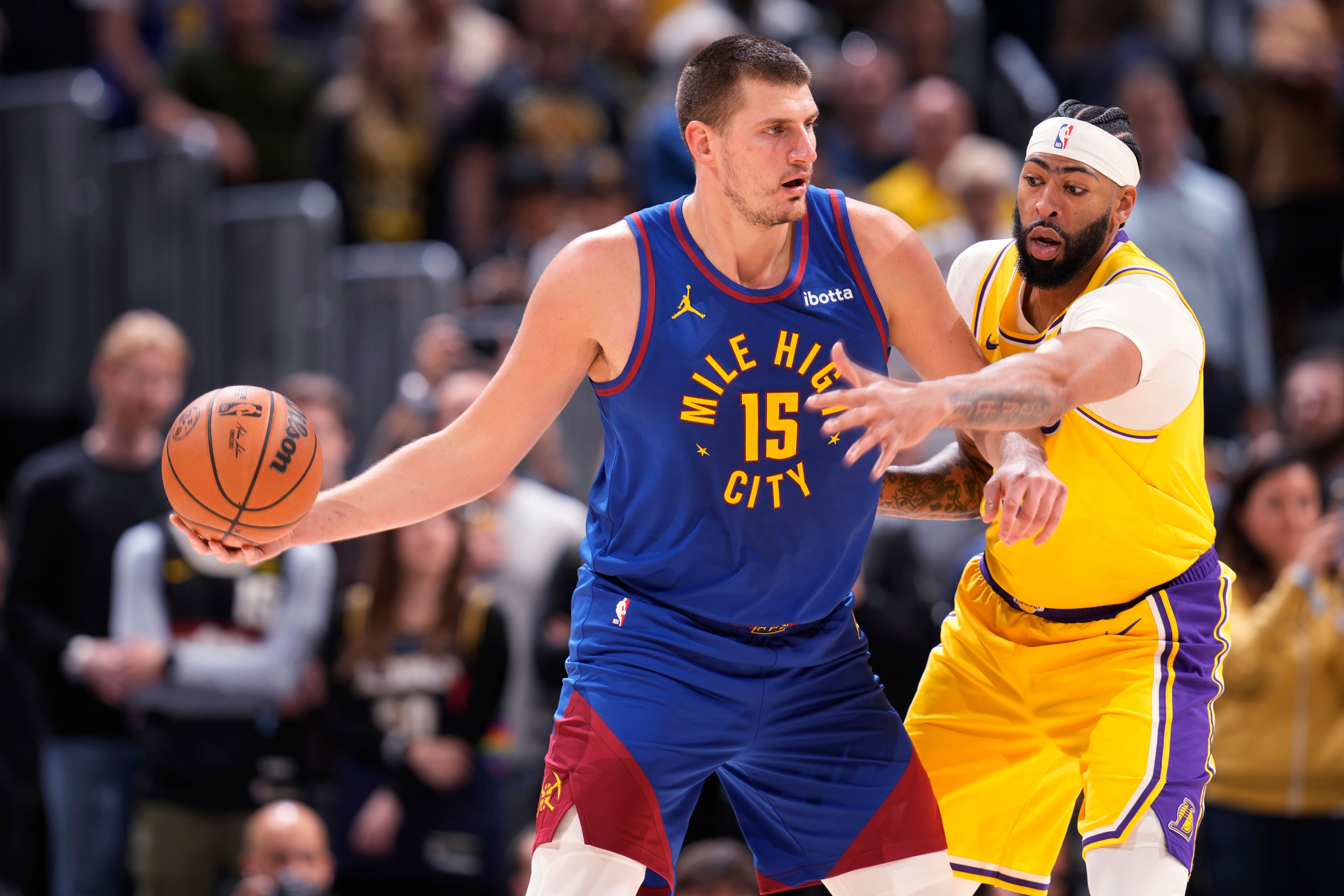 Denver Nuggets centre Nikola Jokic, left, looks to pass the ball as Los Angeles Lakers forward Anthony Davis defends (David Zalubowski/AP)