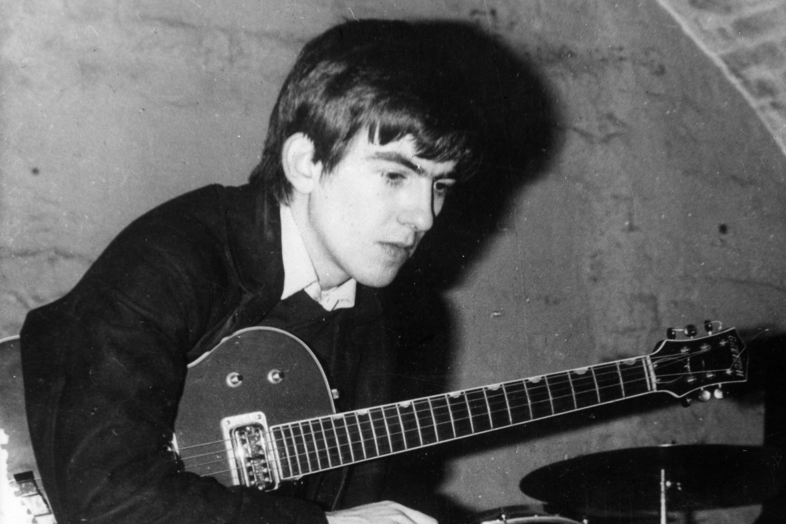 The quiet one: Harrison with his guitar tucked under his arm, taking a break from playing at the Cavern, Liverpool, 1960