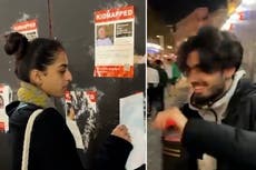 Smiling people rip down posters of kidnapped Israeli children in London’s Leicester Square