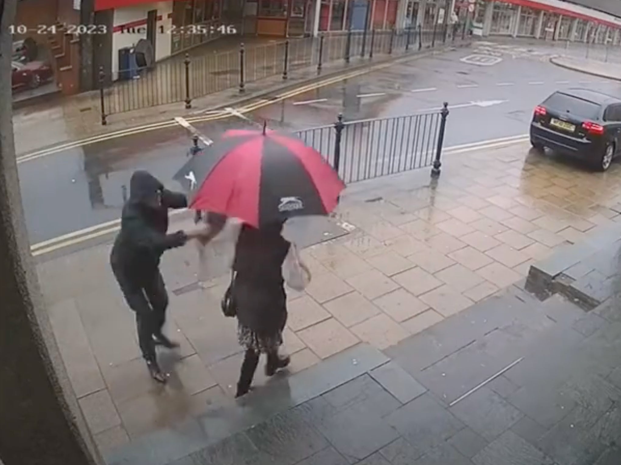 The hooded man raises the concrete block and brings it down on the victim’s head