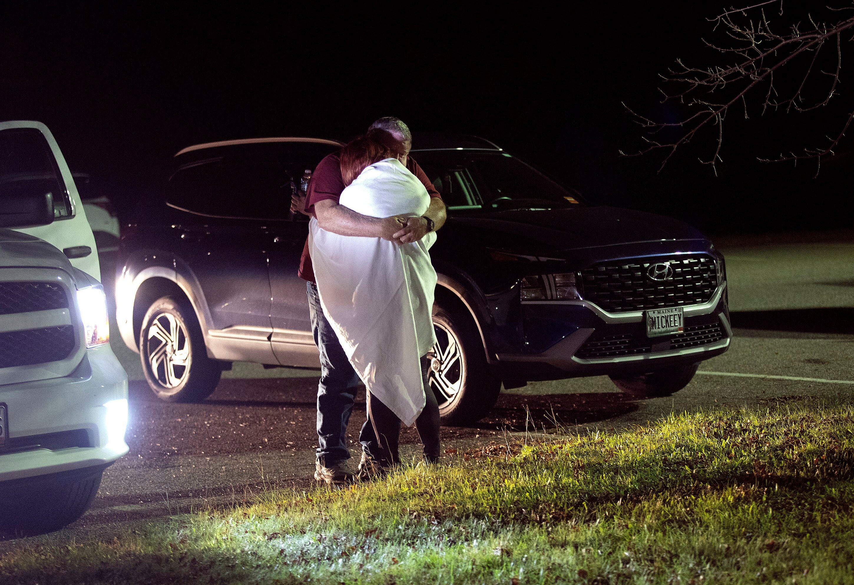 A woman is hugged by a man at a reunification centre at Auburn Middle School