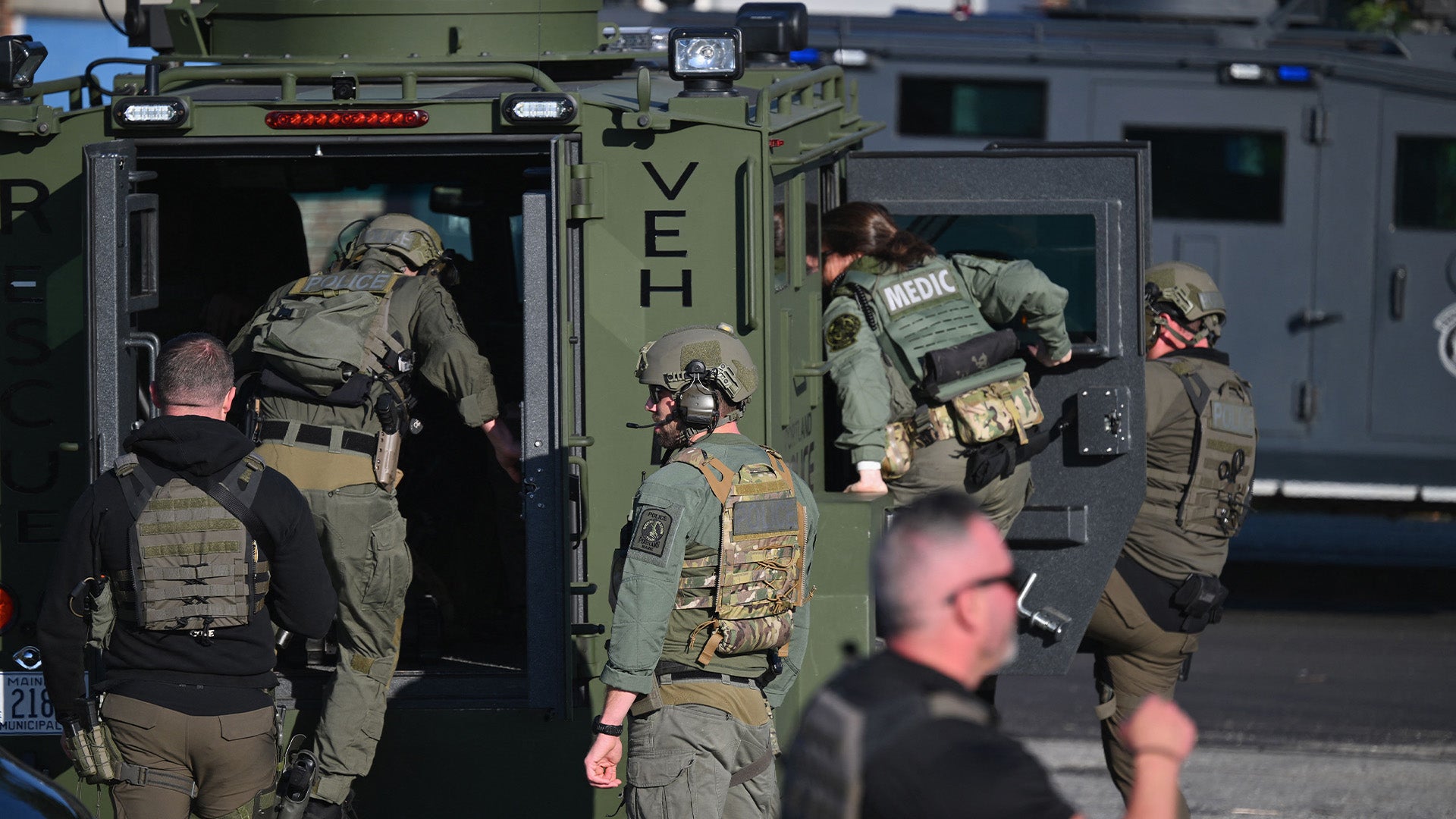 Law enforcement officials load into a vehicle in Lewiston