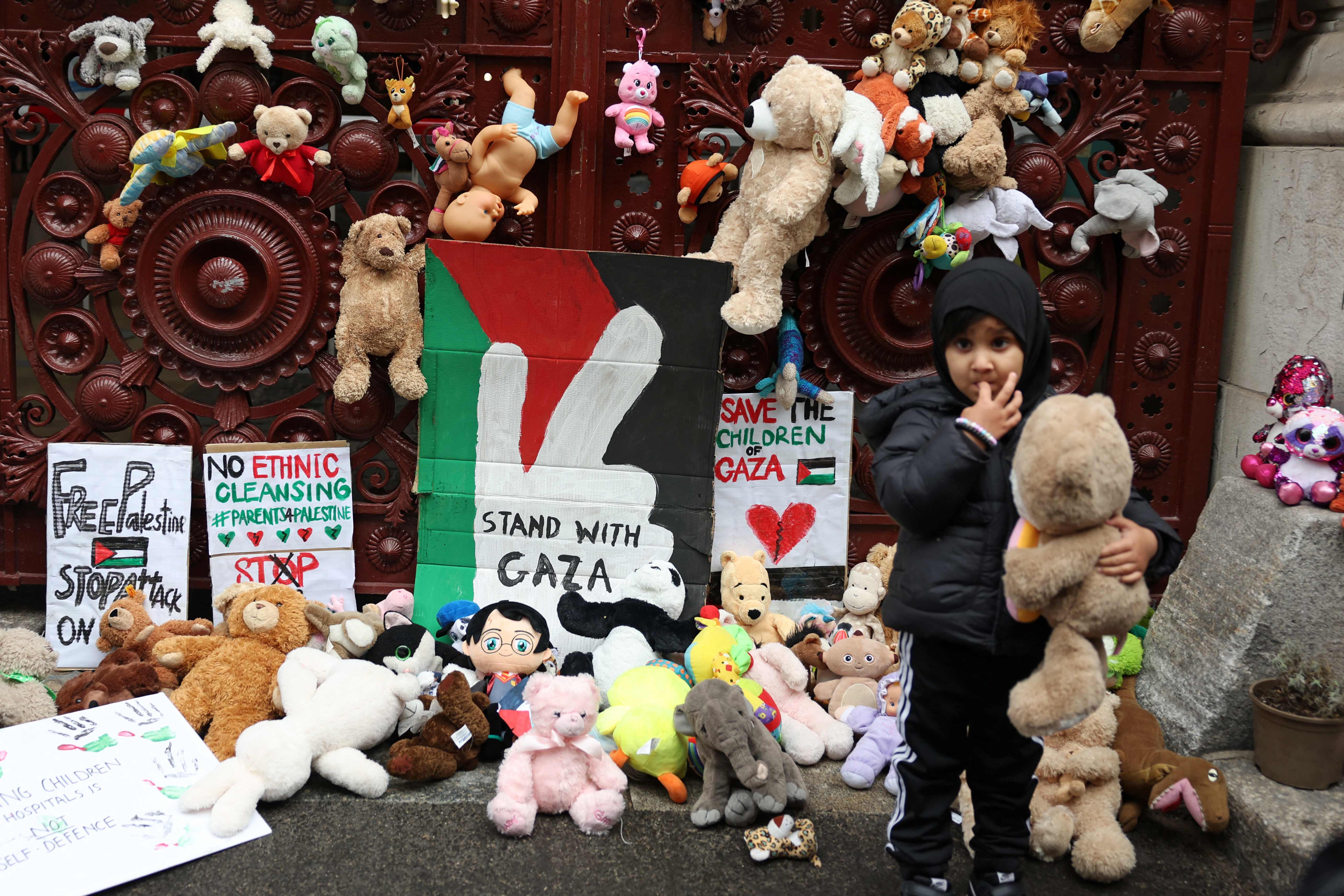 Young children bring teddy bears and other soft toys representing children killed in Gaza, to the gates of the Foreign, Commonwealth and Development Office in London on 27 October