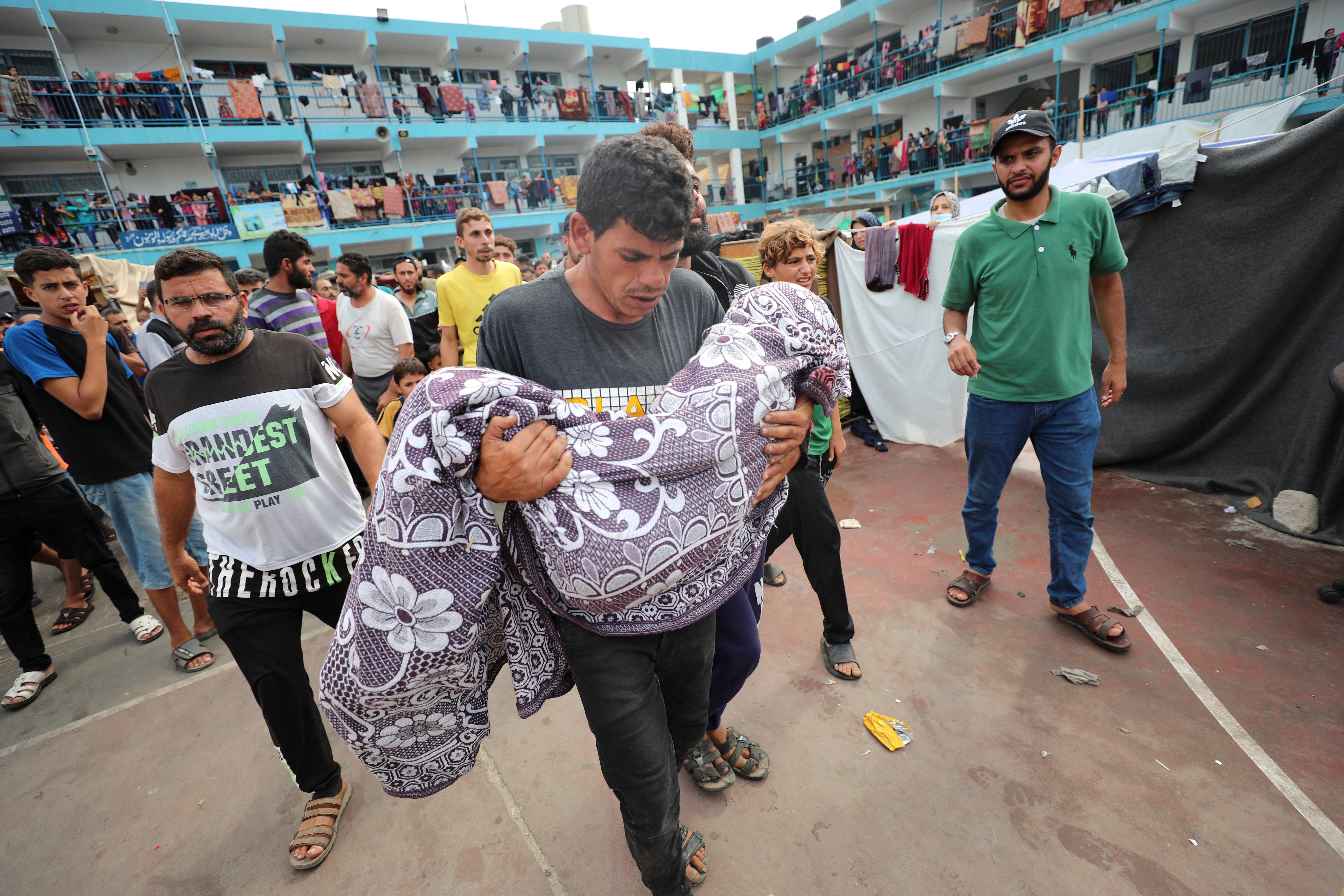 Palestinians carry a child killed in the Israeli bombardment of the Gaza Strip