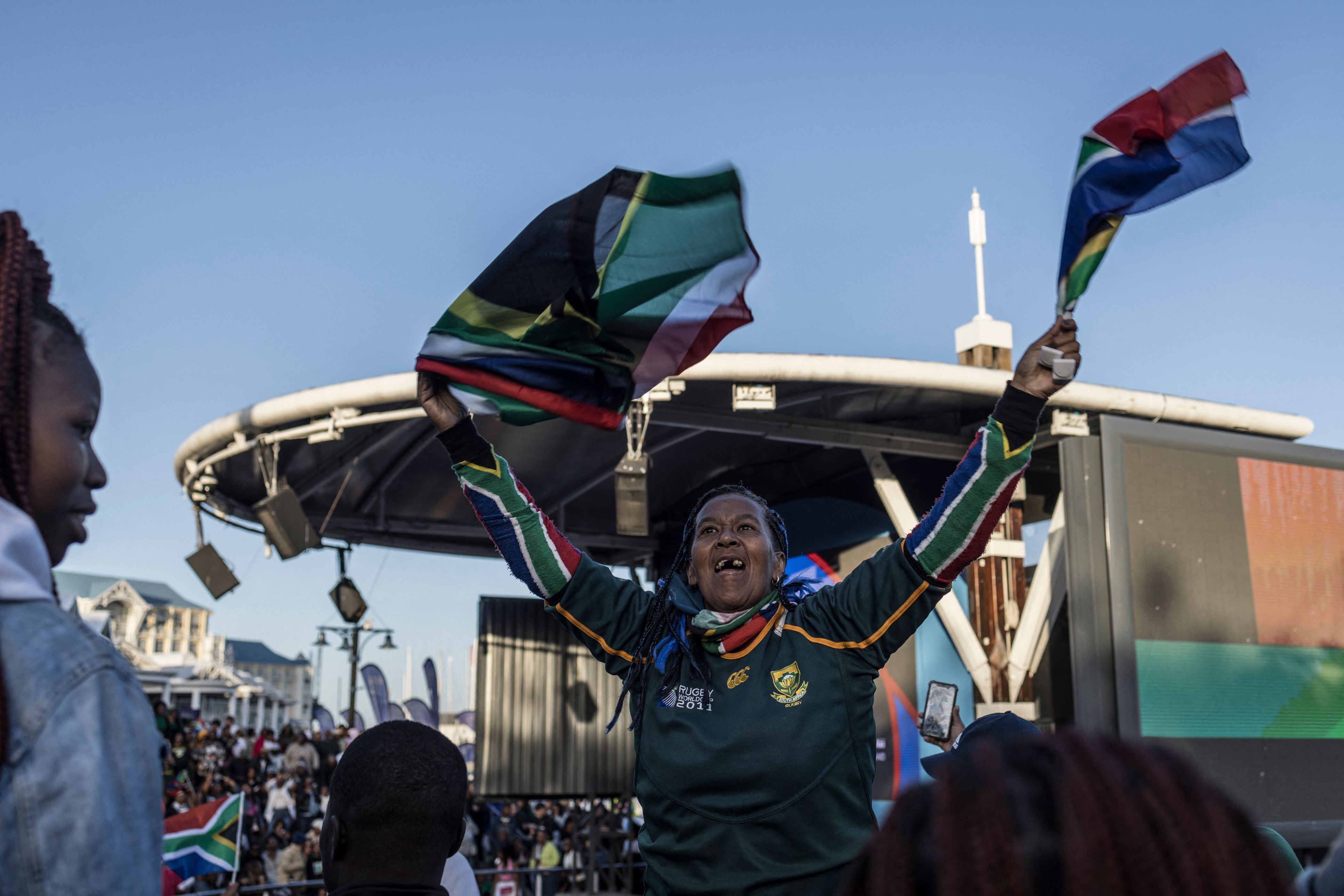 A South African supporter waves flags among fans gathering at the V&A Waterfront Mall in Cape Town