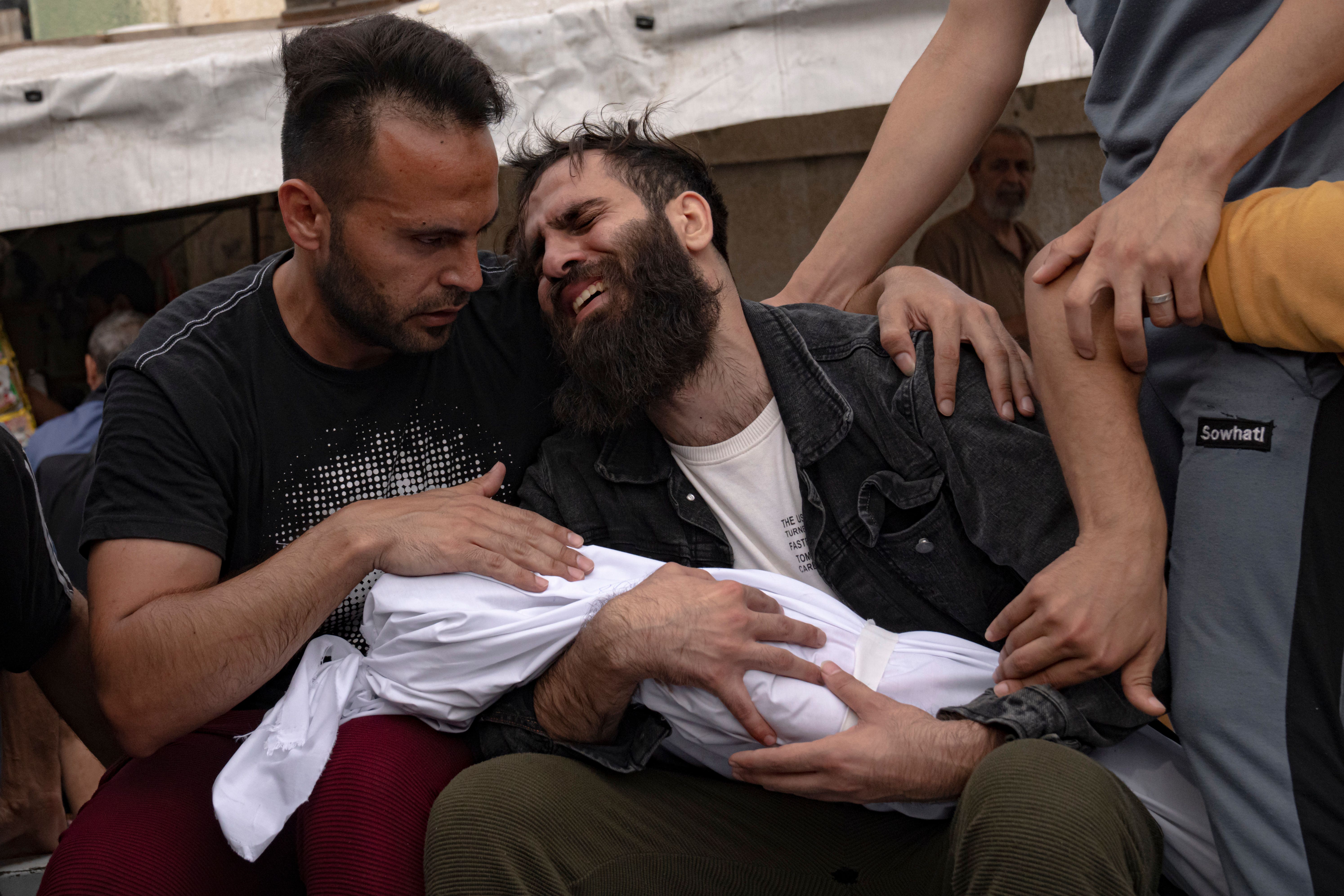 Palestinians mourn relatives killed in the Israeli bombardment of the Gaza Strip, in a morgue in Khan Younis (Fatima Shbair/AP)