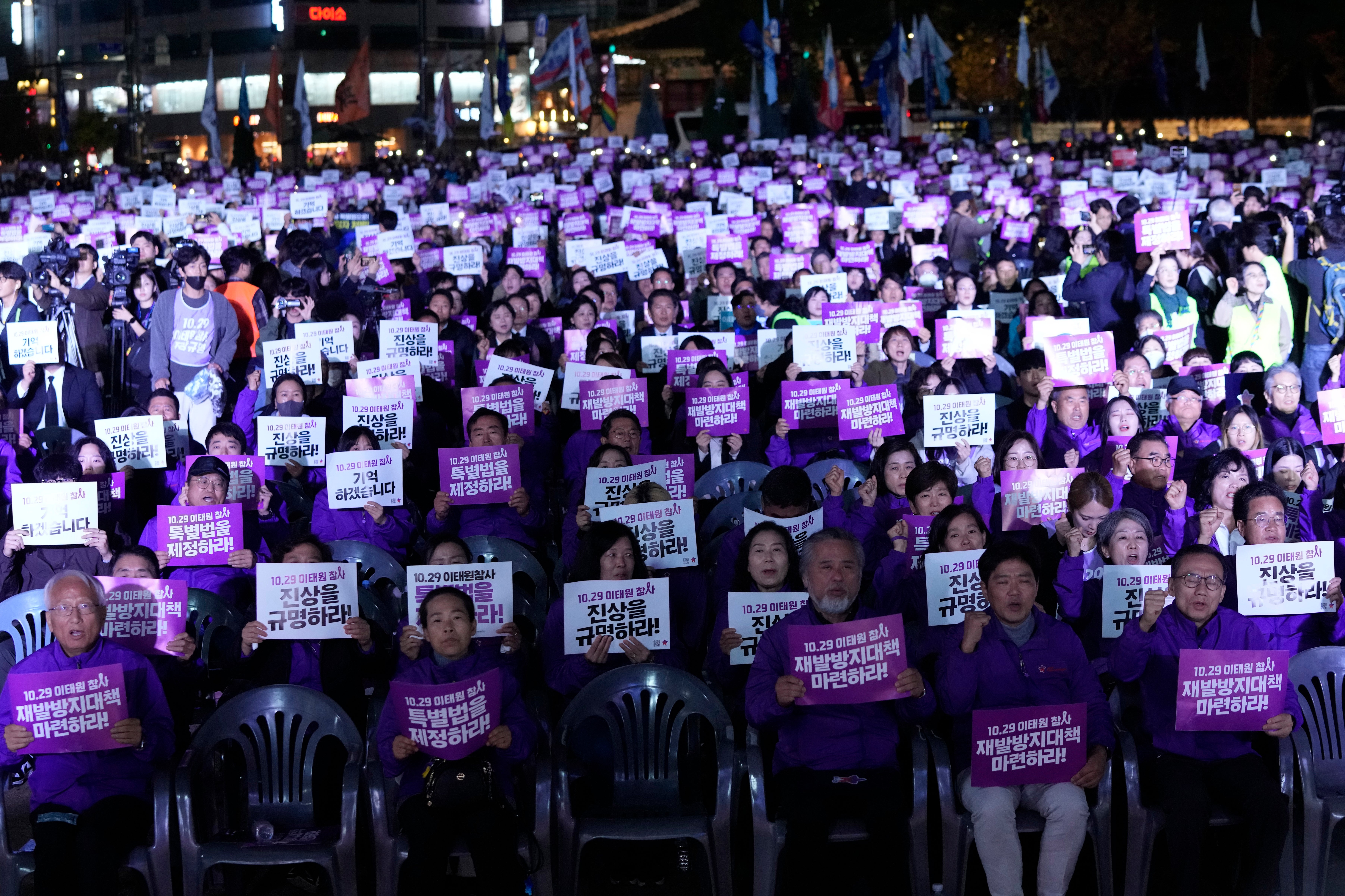 People attending the rally hold signs that read: ‘Find out the truth’