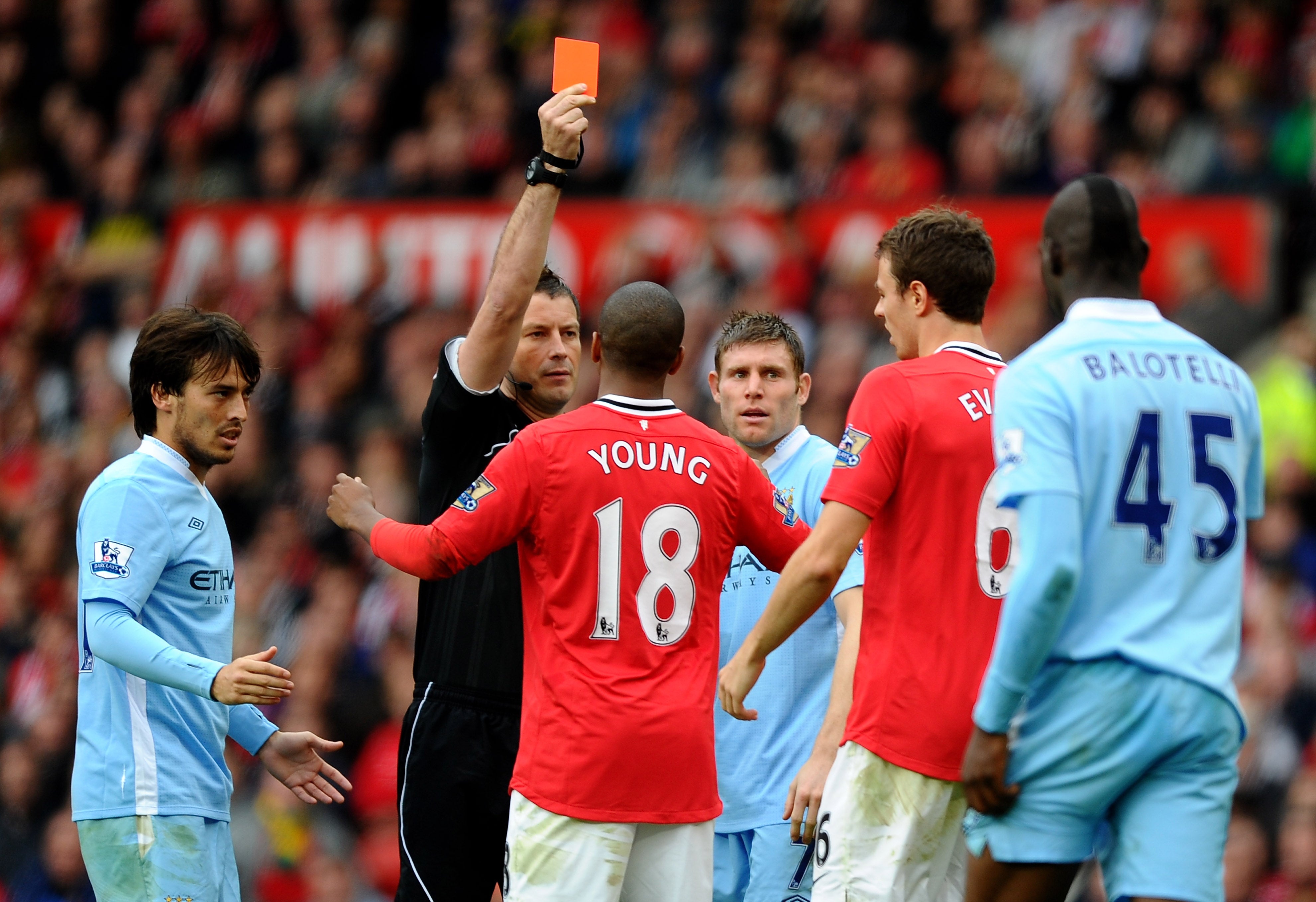 Referee Mark Clattenburg shows a red card to Jonny Evans of Manchester United in 2011