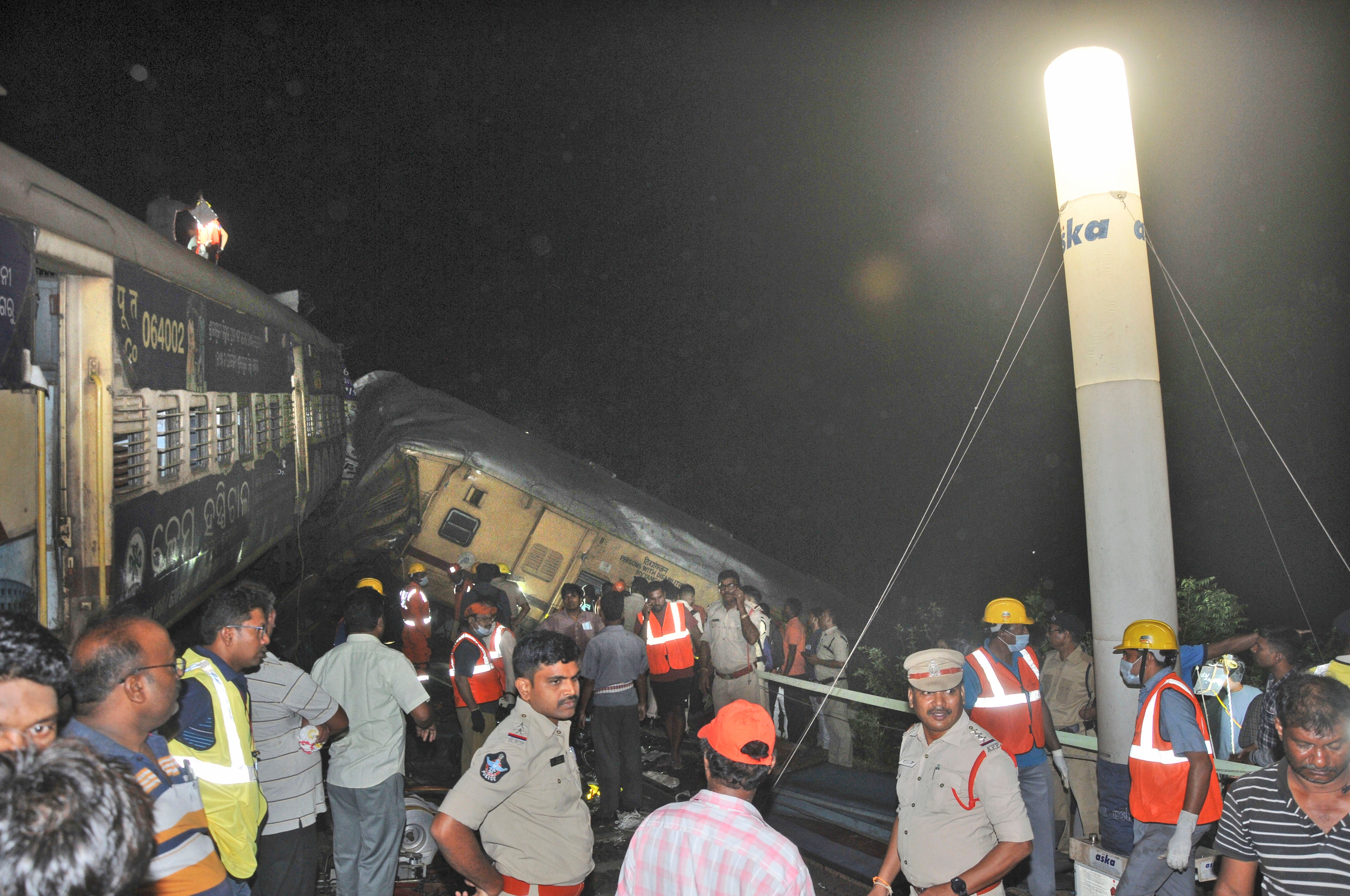 Rescuers and others stand after two passenger trains collided in Vizianagaram district, Andhra Pradesh state