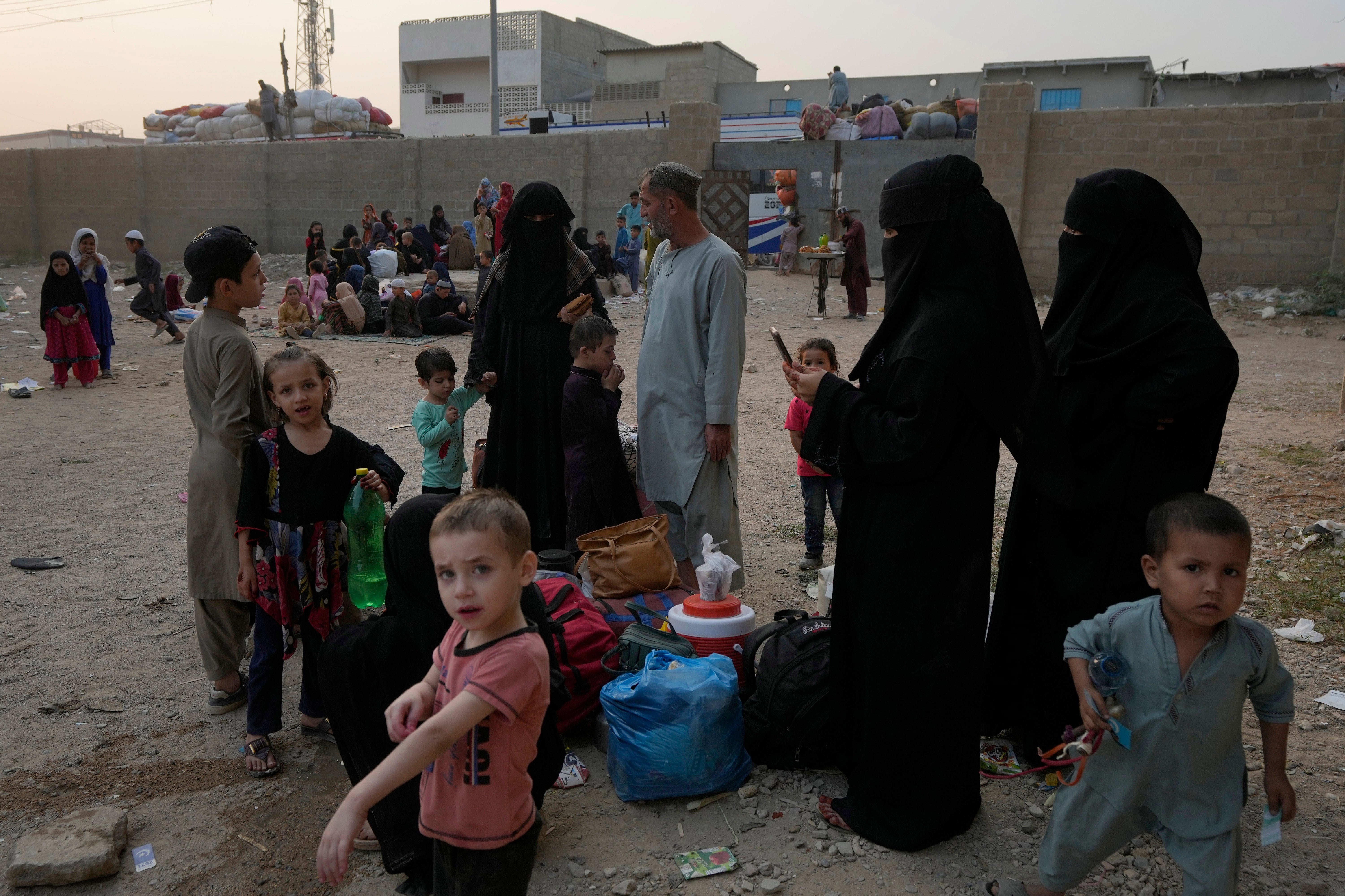 Afghan families wait in Karachi, Pakistan for transport to take them to their homeland