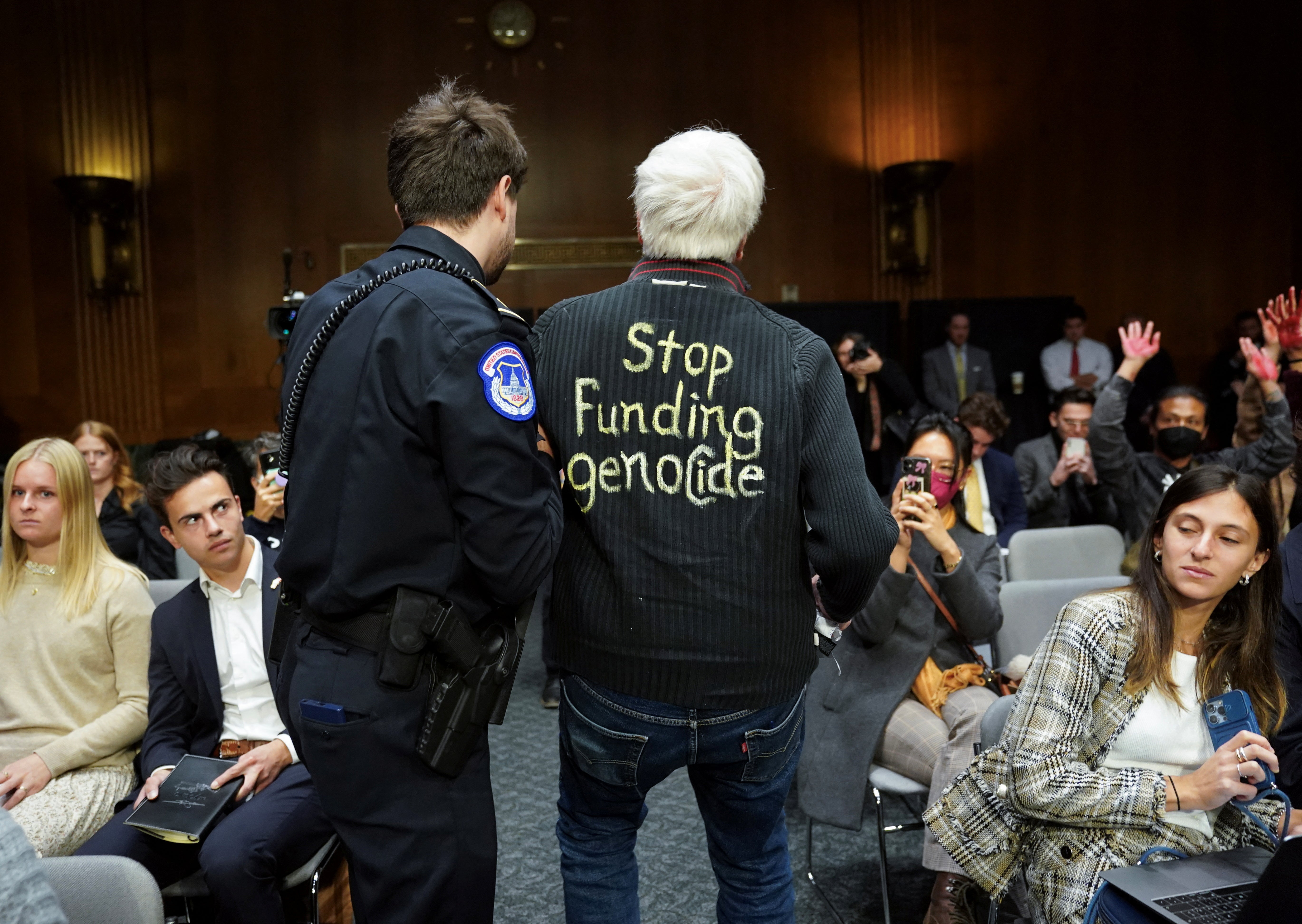 An anti-war protester wearing "stop funding genocide" on his shirt, is removed by police during a Senate Appropriations Committee hearing on President Biden's $106 billion national security supplemental funding request to support Israel and Ukraine