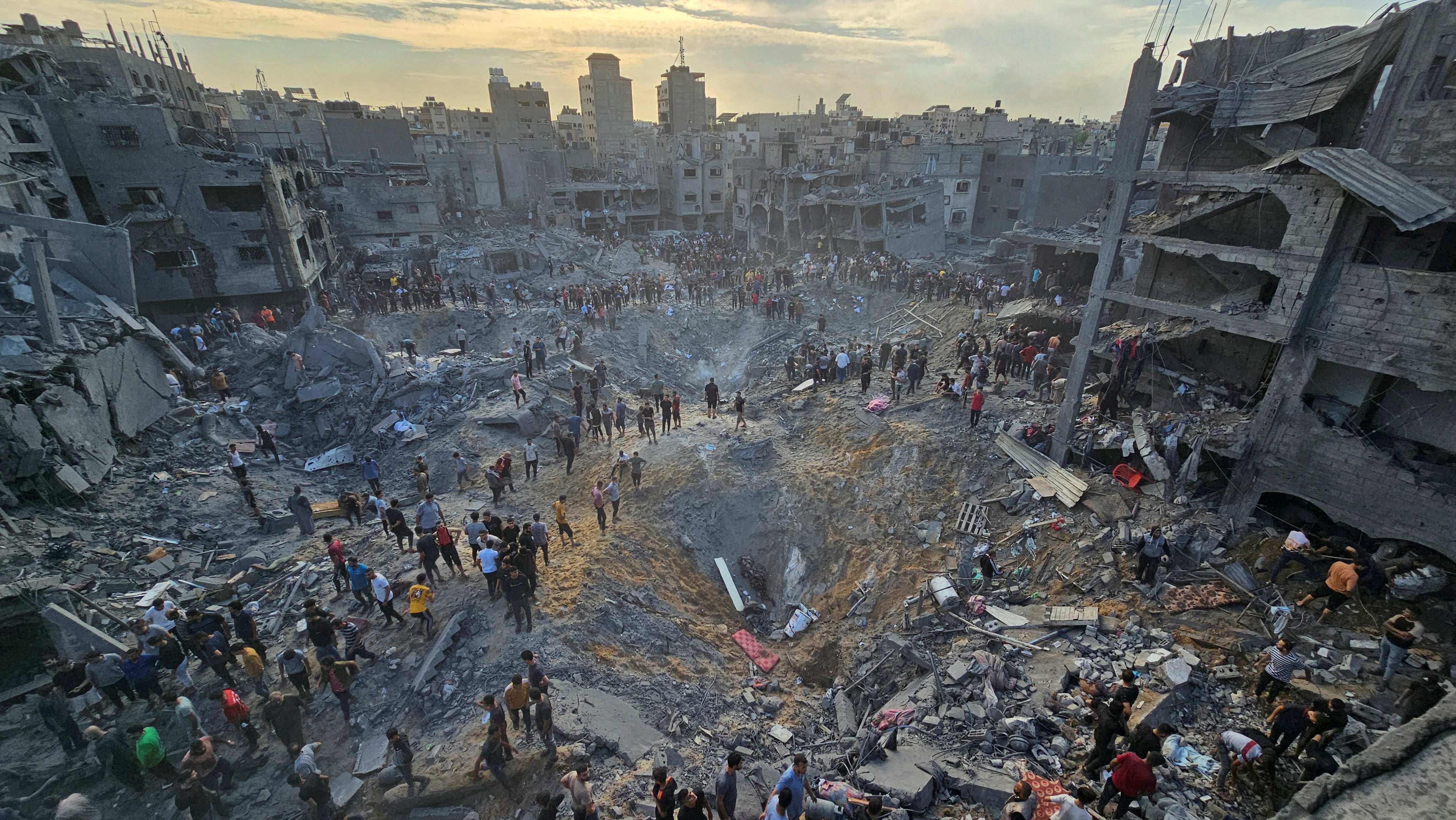 Palestinians search for survivors at the site of Israeli strikes on houses in the Jabaliya refugee camp