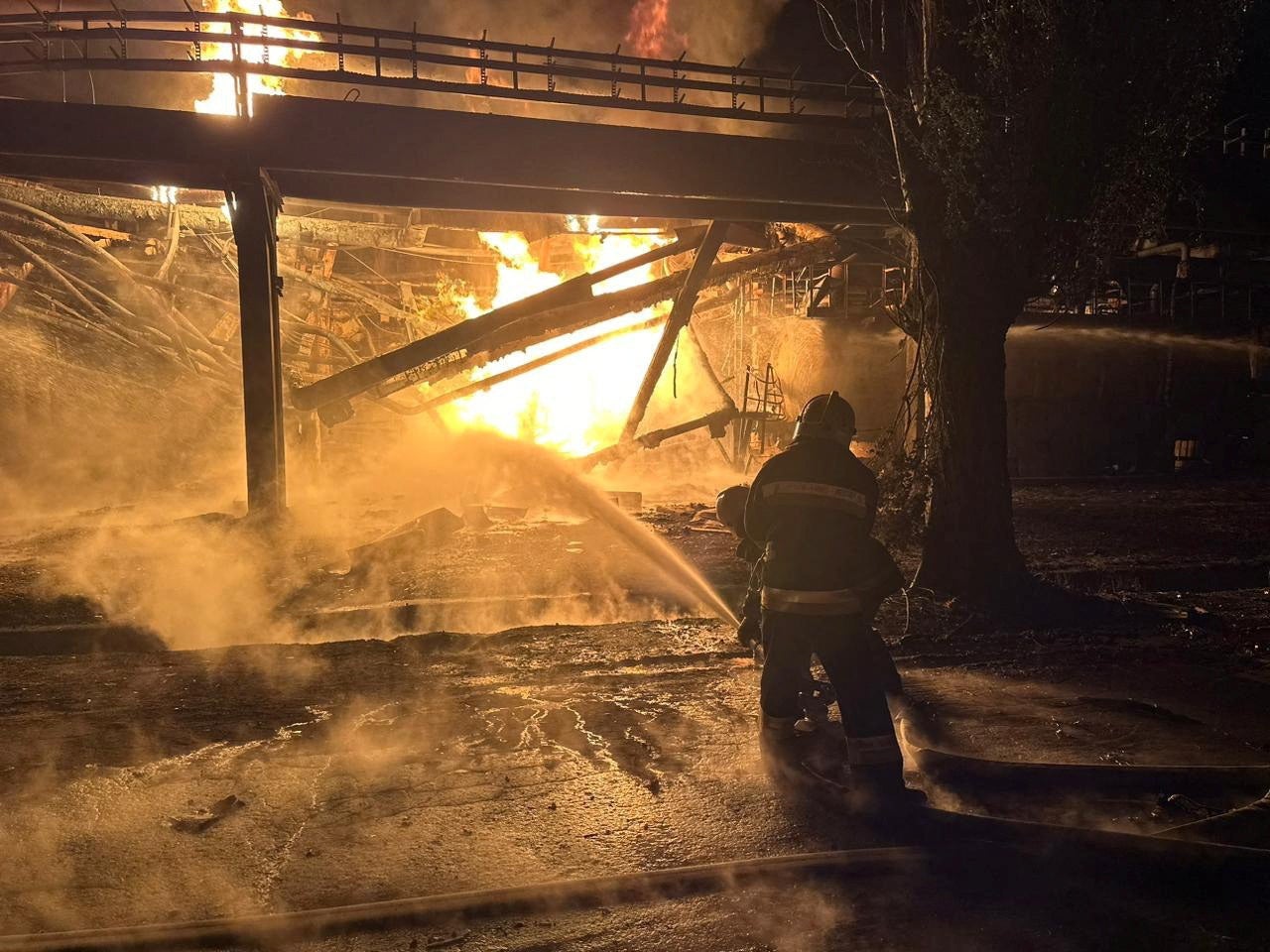 Firefighters work at an oil refinery hit during Russia’s drone attacks in Kremenchuk