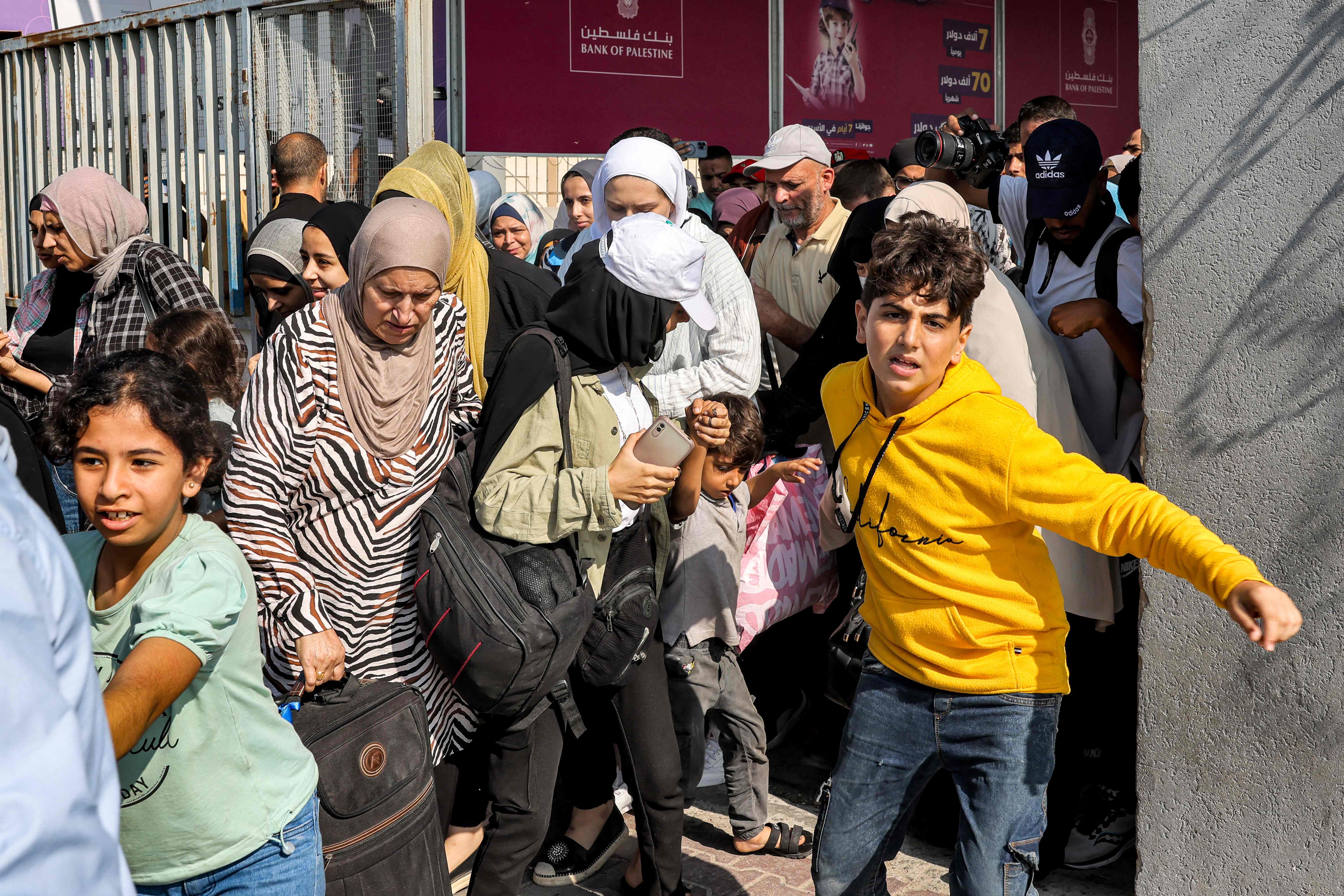 People walk through a gate to enter the Rafah border crossing to Egypt