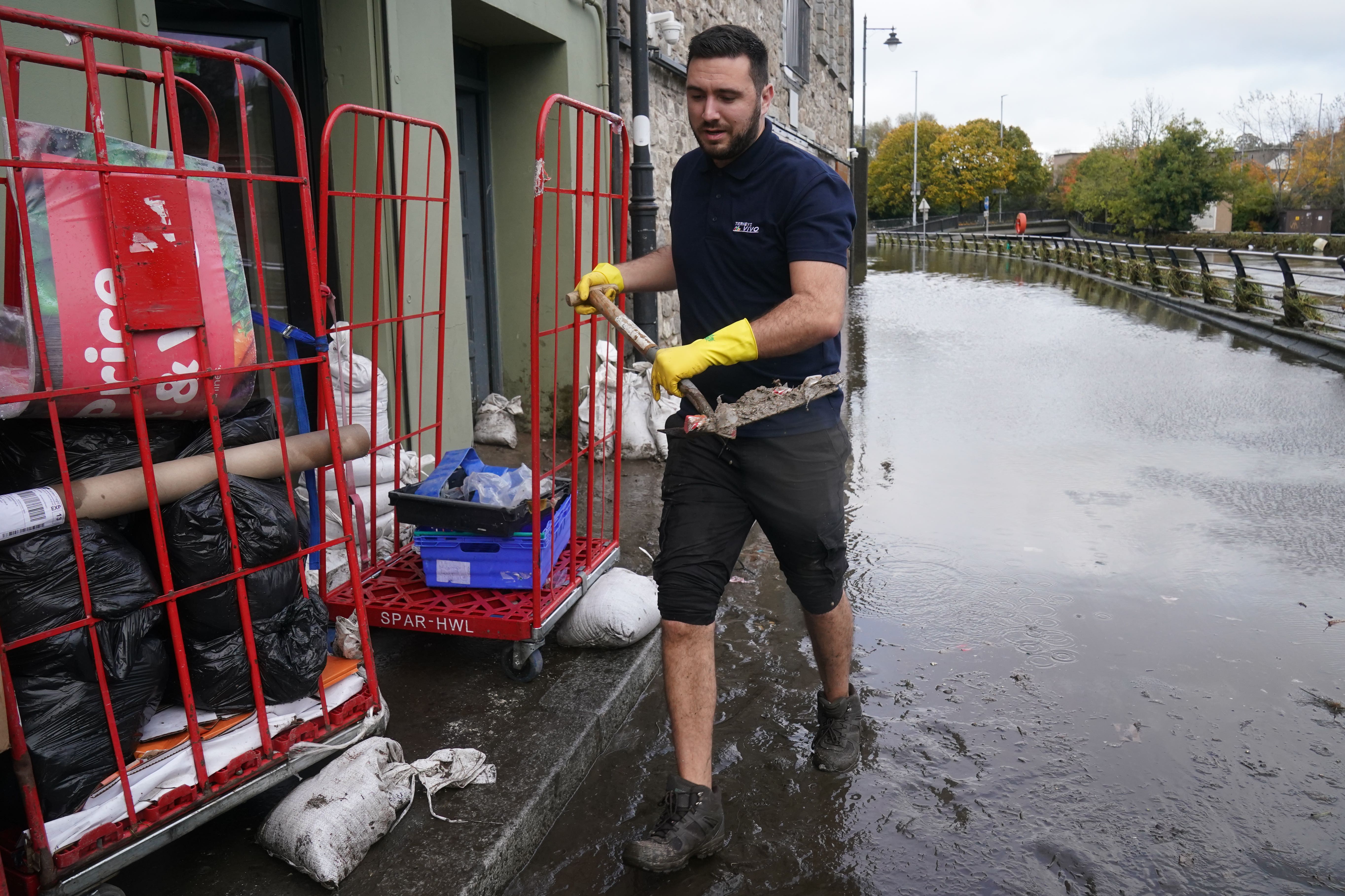 Ross Campbell clears out a damaged property in Newry, Co Down, after the city’s canal burst its banks during heavy rainfall (Brian Lawless/PA)