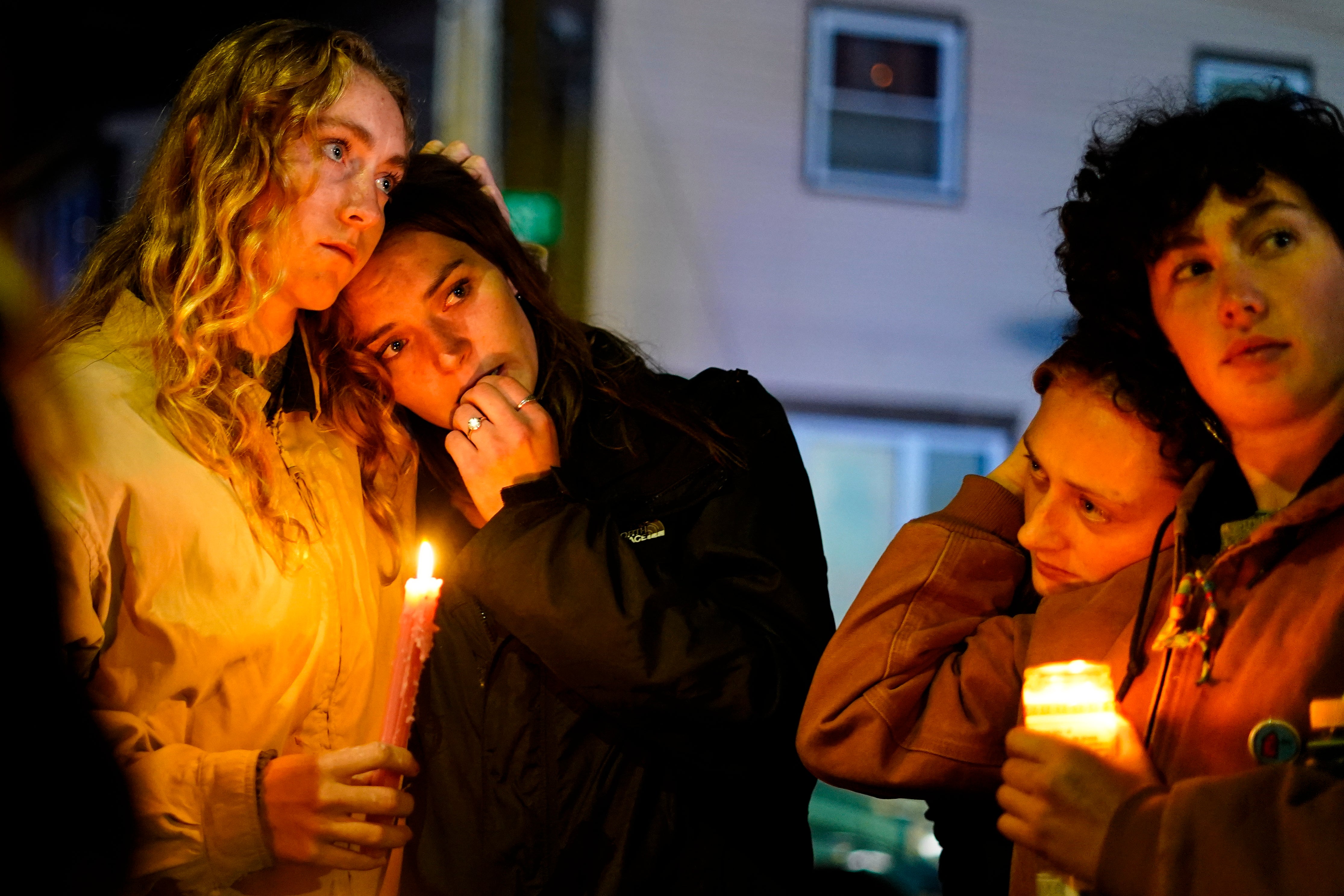 People linger after a vigil for the victims of Wednesday’s mass shootings, Sunday, Oct. 29, 2023