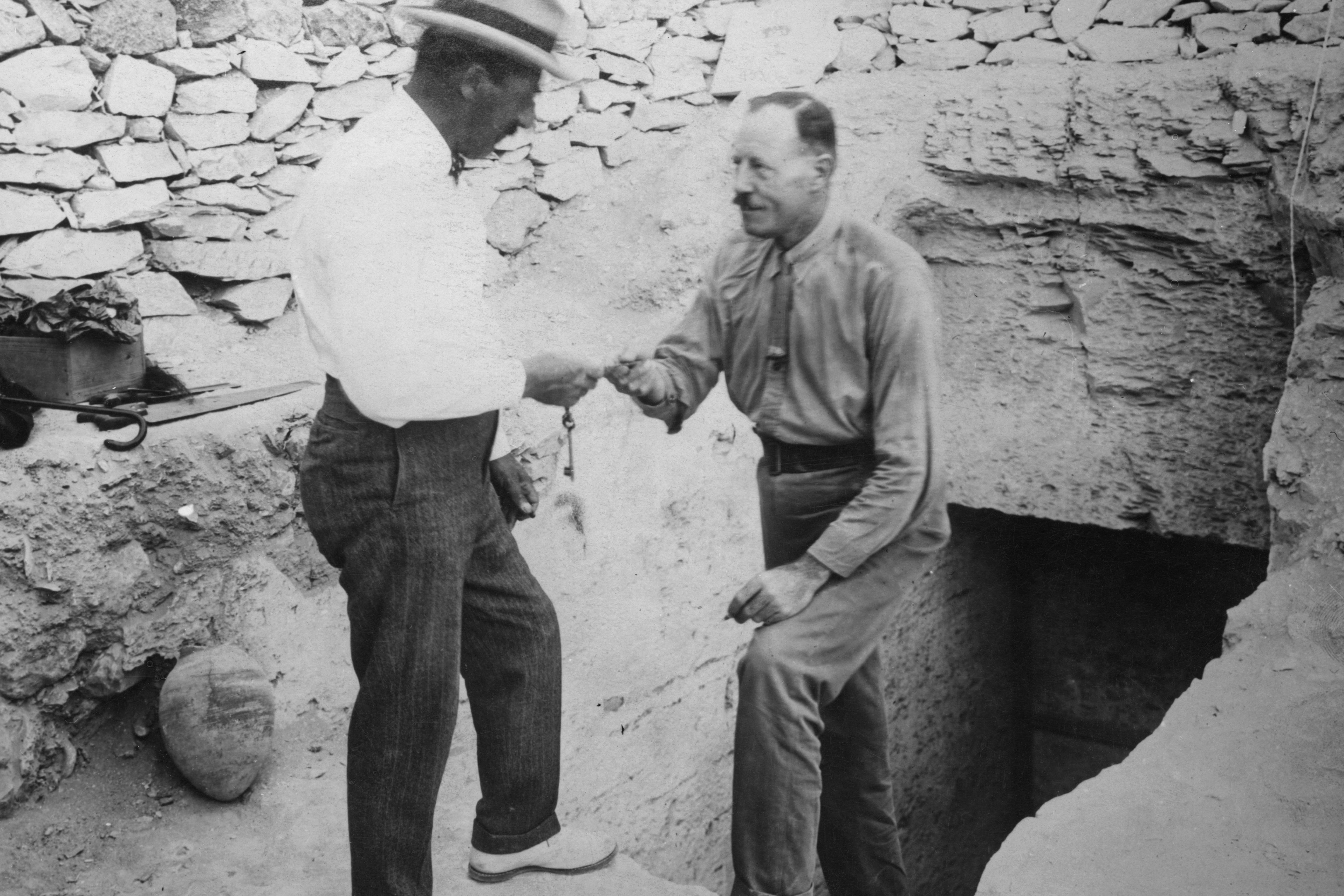 The British archaeologist Howard Carter (right) hands over the key to the recently discovered tomb of Tutankhamun (designated KV62) in the Valley of the Kings, Egypt, circa 1922