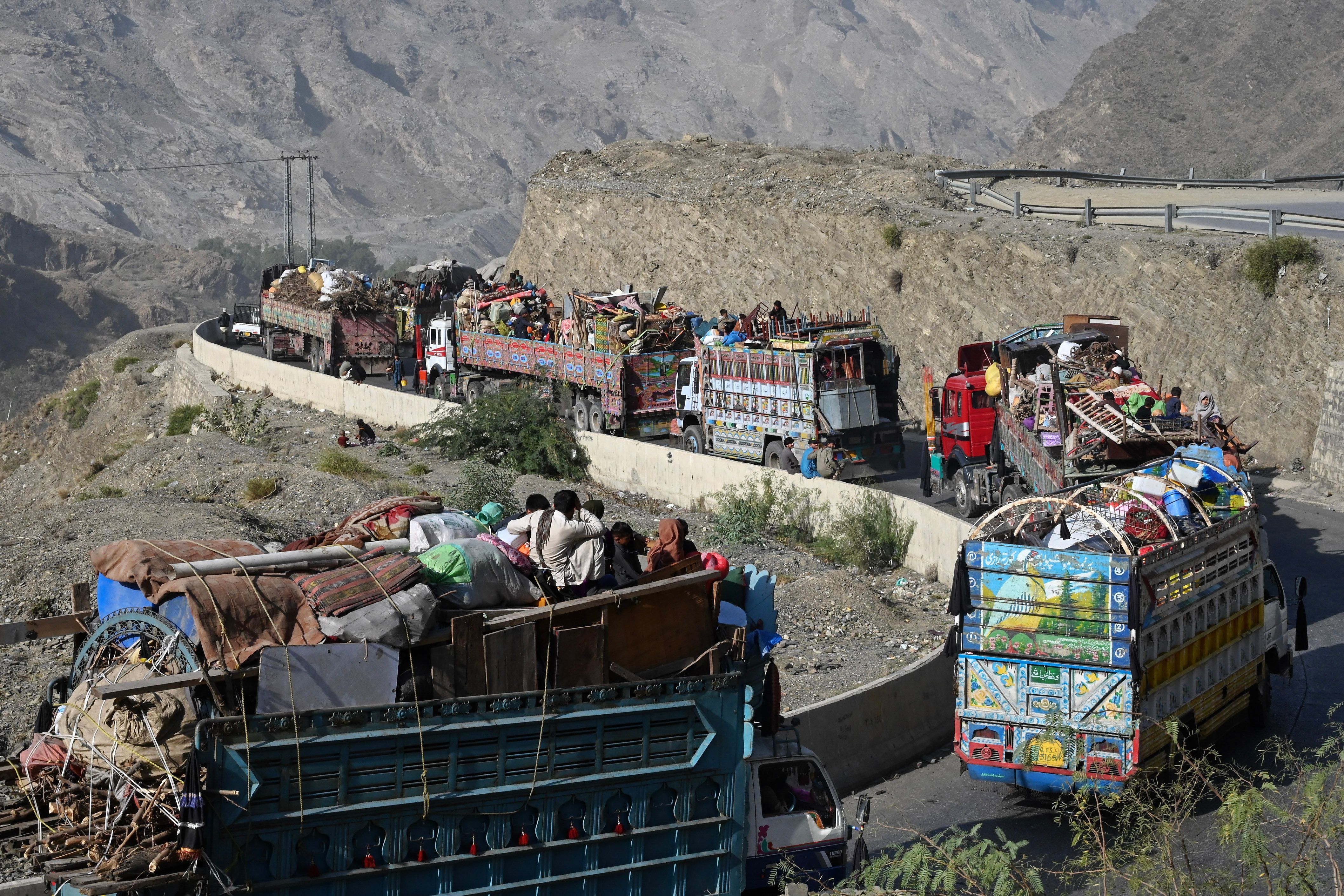 Trucks transporting Afghan refugees with their belongings are seen along a road towards the Pakistan-Afghanistan Torkham border