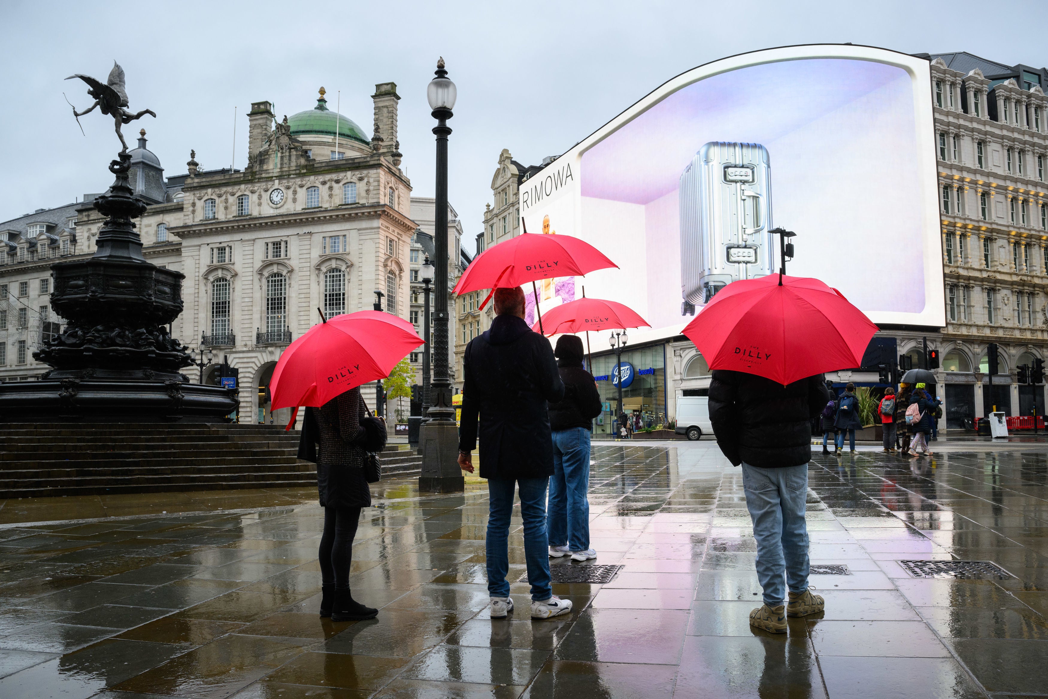 People with umbrellas in the wet weather in Piccadilly Circus, London